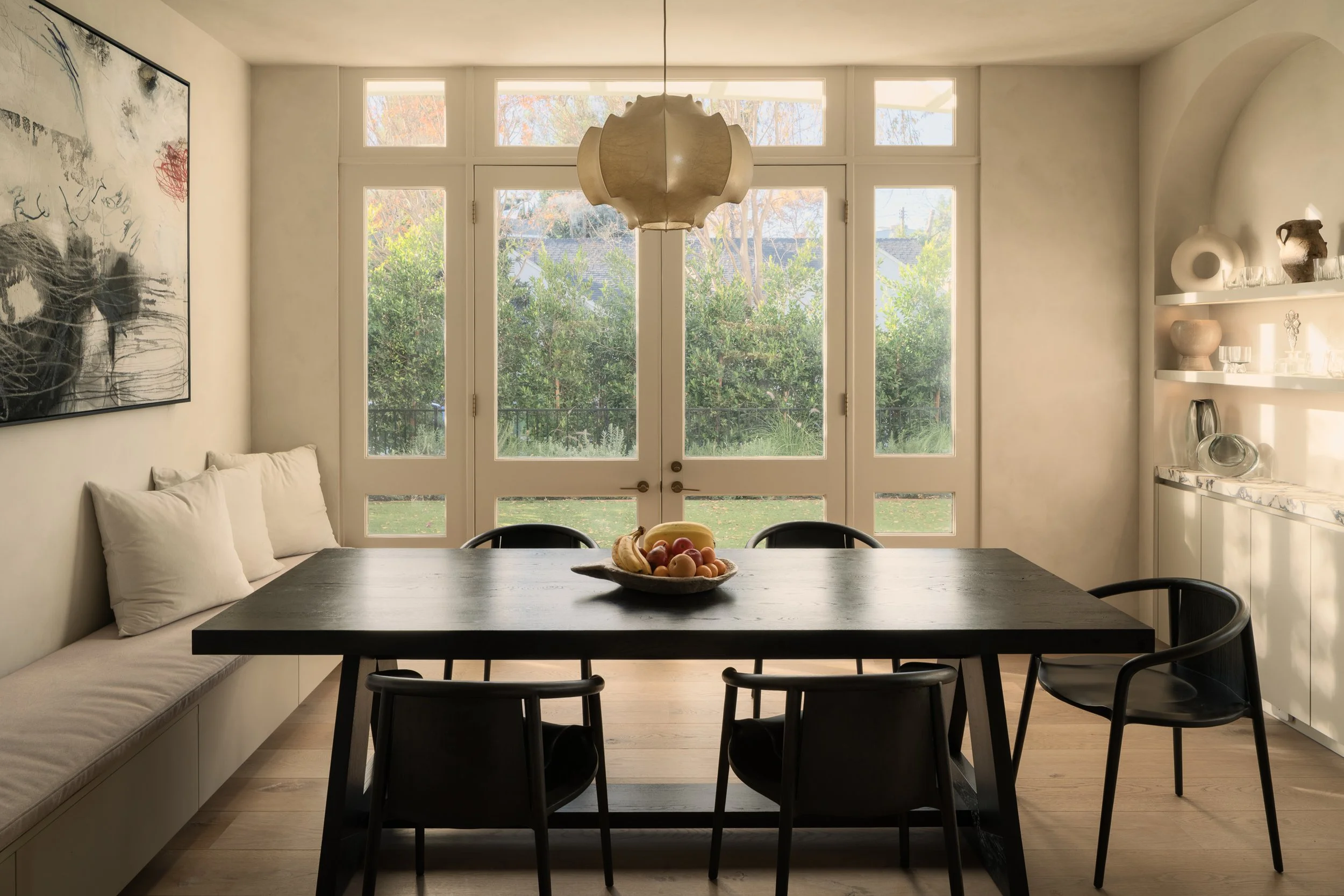 Contemporary dining room with large picture windows overlooking the landscaped yard, completed by JBurton General Contractor for a luxury home remodel in Benedict Canyon, Los Angeles.
