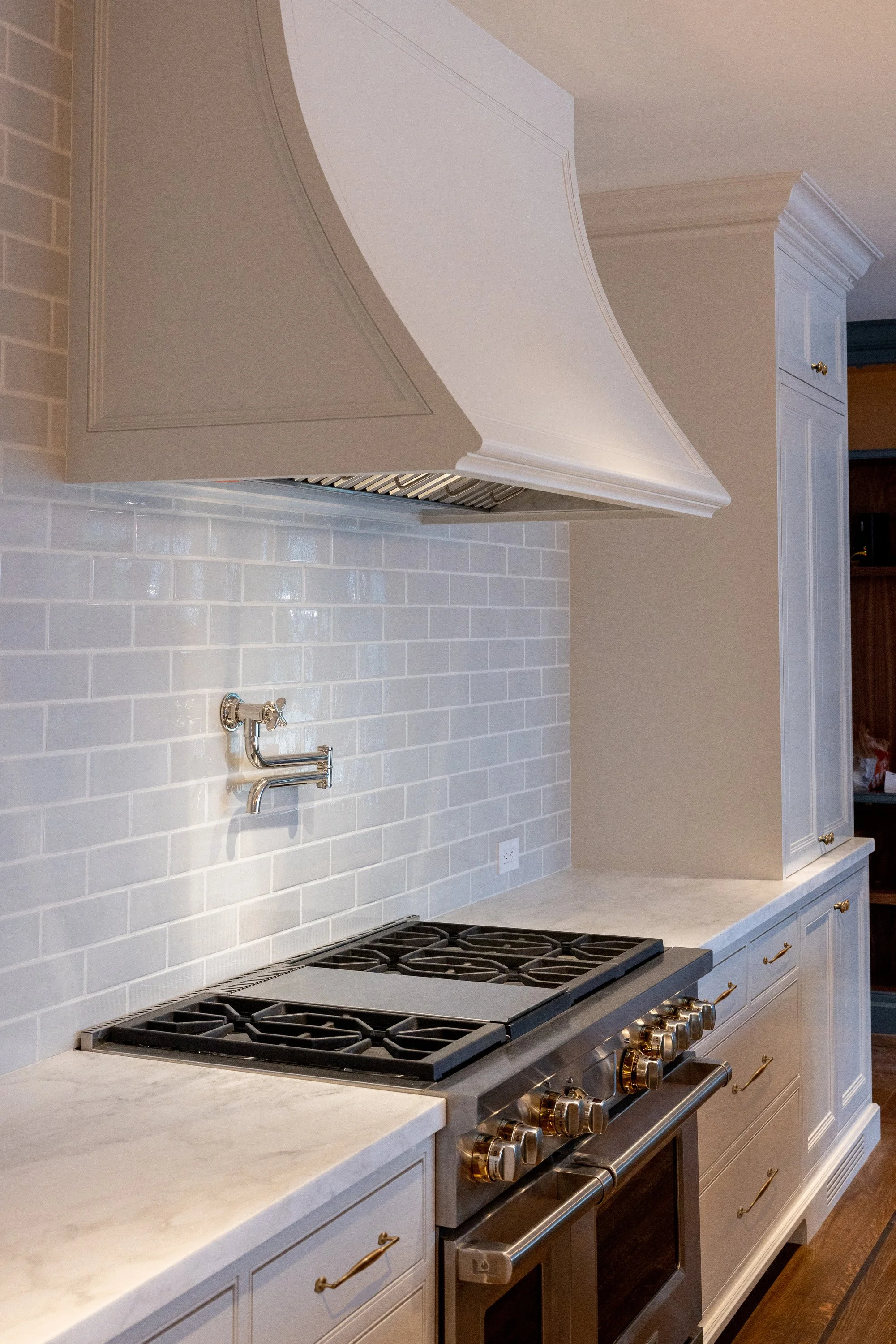 Custom kitchen featuring a professional range, plaster hood, and classic subway tile backsplash, remodeled by JBurton General Contractor in Hancock Park, Los Angeles.