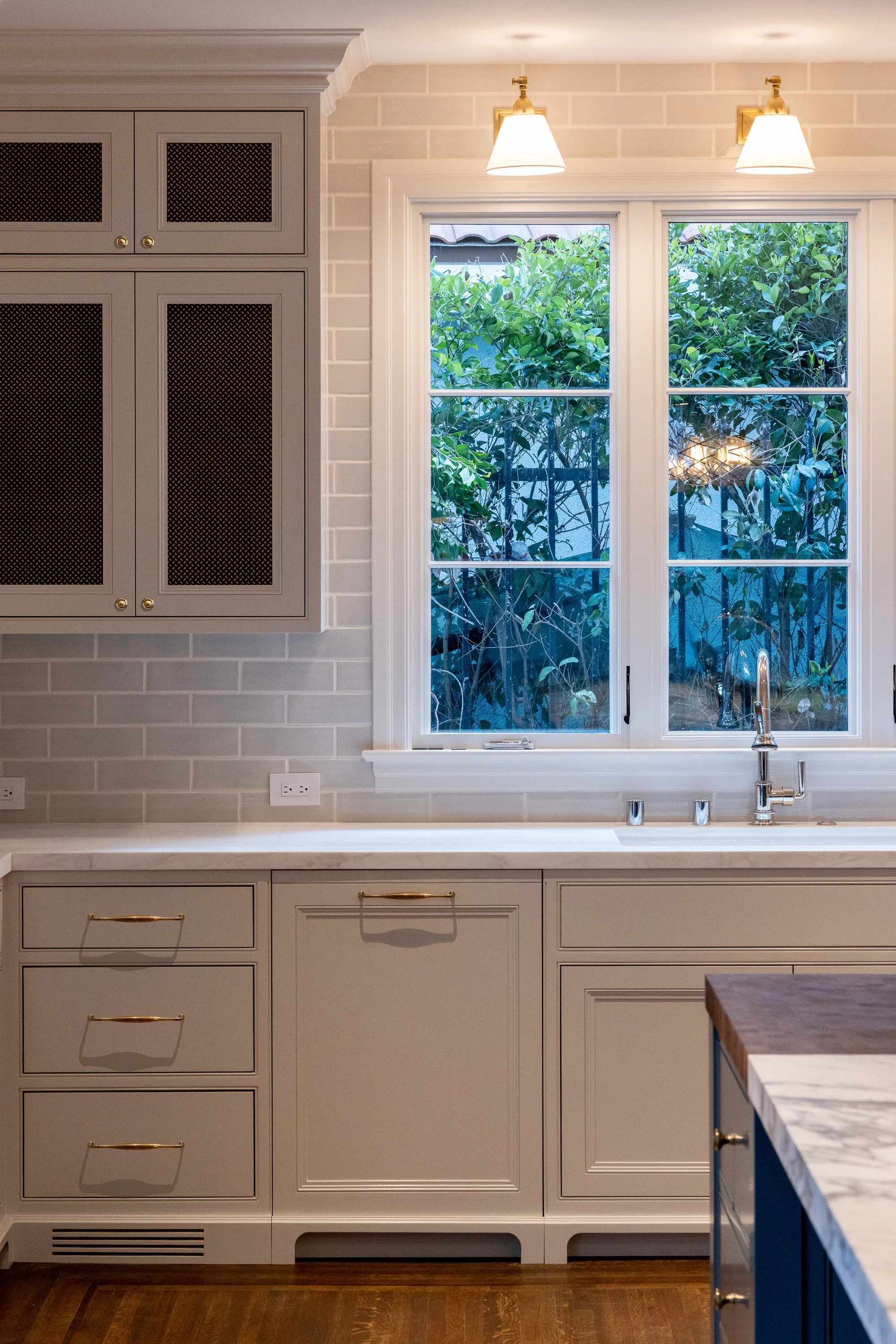 Kitchen window overlooking the garden with custom cabinetry and subway tile backsplash, remodeled by JBurton General Contractor in Hancock Park, Los Angeles.