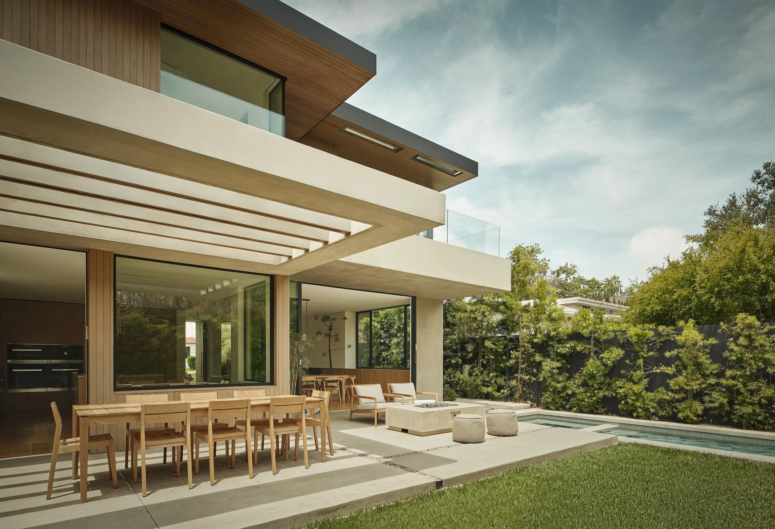 Modern backyard with covered outdoor dining, lounge area, and landscaped lawn, remodeled by JBurton General Contractor in Westwood, Los Angeles.