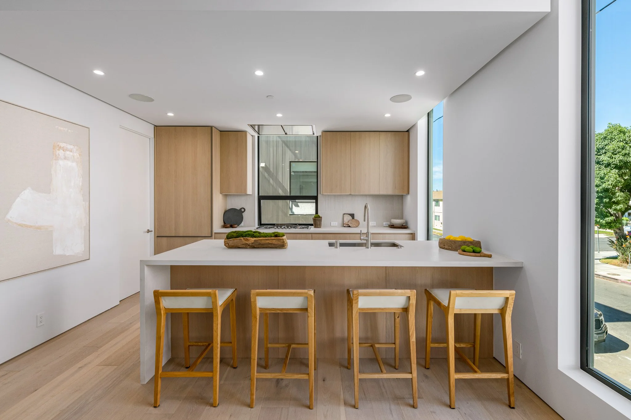 Contemporary kitchen with a generous quartz island, custom wood cabinetry, and integrated storage solutions, built by JBurton General Contractor.