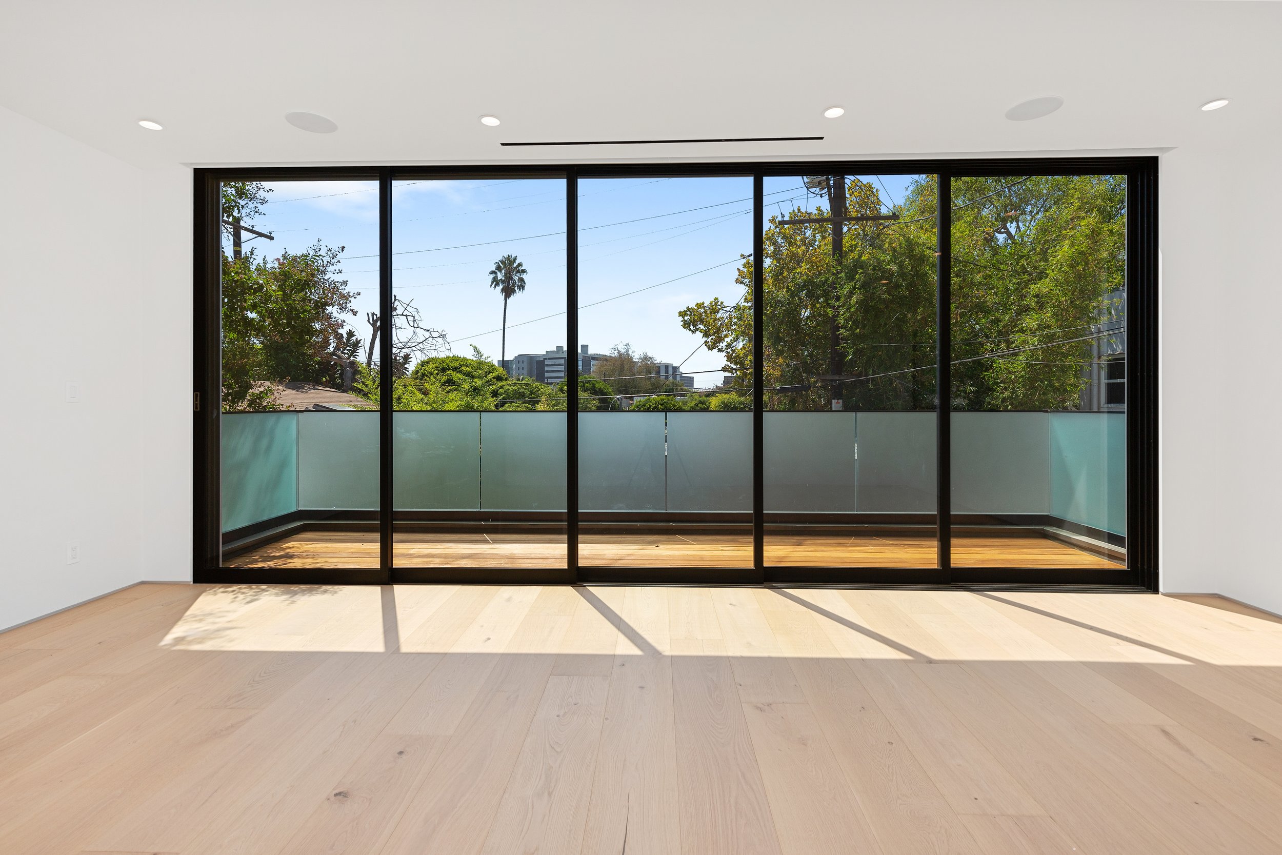 Bright open living space with floor-to-ceiling sliding glass doors that extend the home to a private outdoor terrace, built by JBurton General Contractor in West Hollywood.
