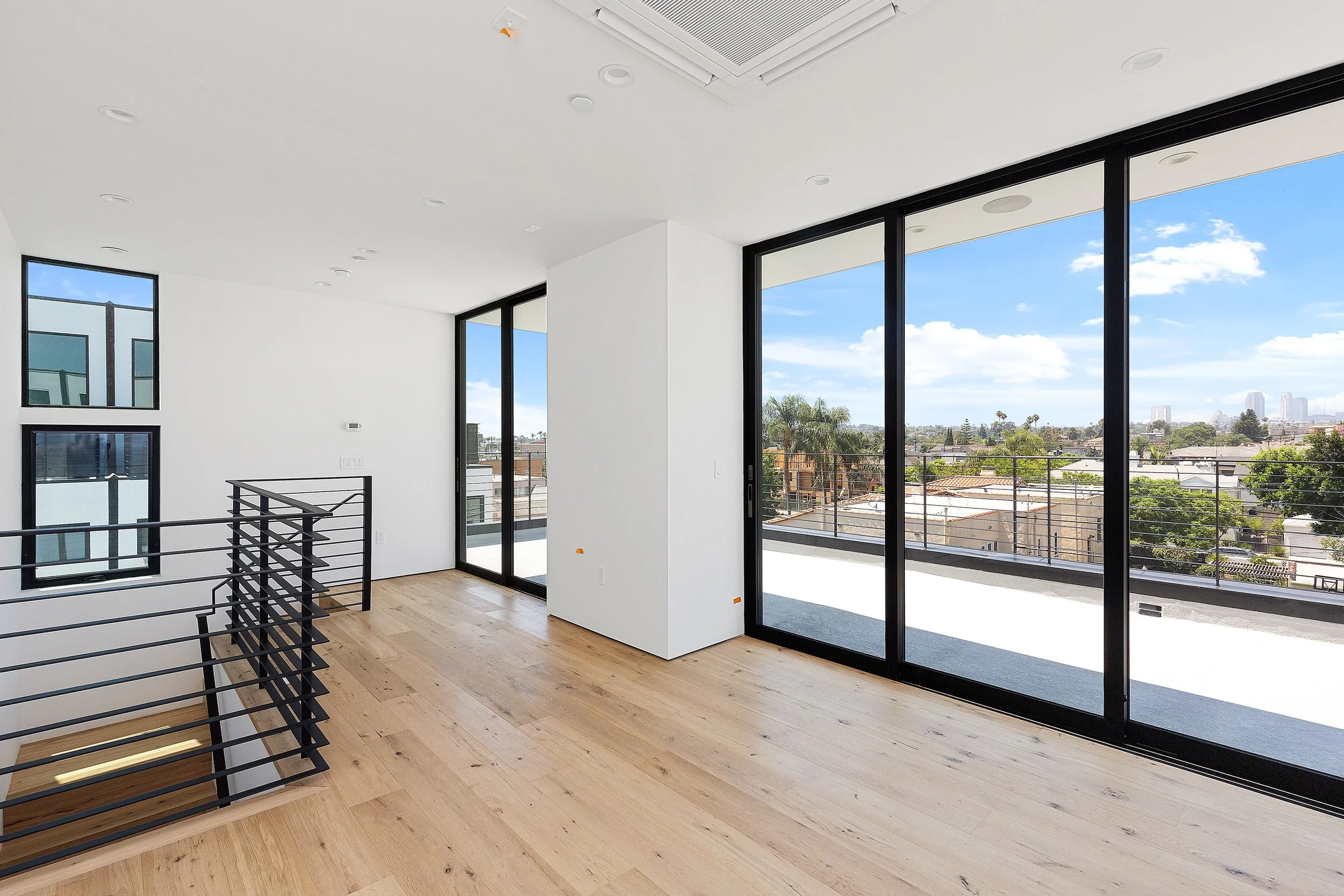 Modern townhome with expansive black-framed sliding glass doors and balcony access, built by JBurton General Contractor in Faircrest Heights, Los Angeles
