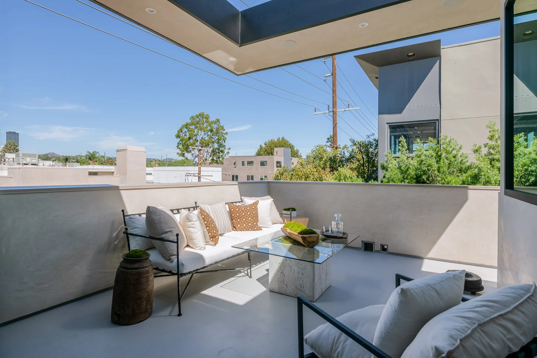 Private terrace designed for outdoor relaxation with comfortable seating, architectural overhangs, and elevated neighborhood views by JBurton General Contractor.