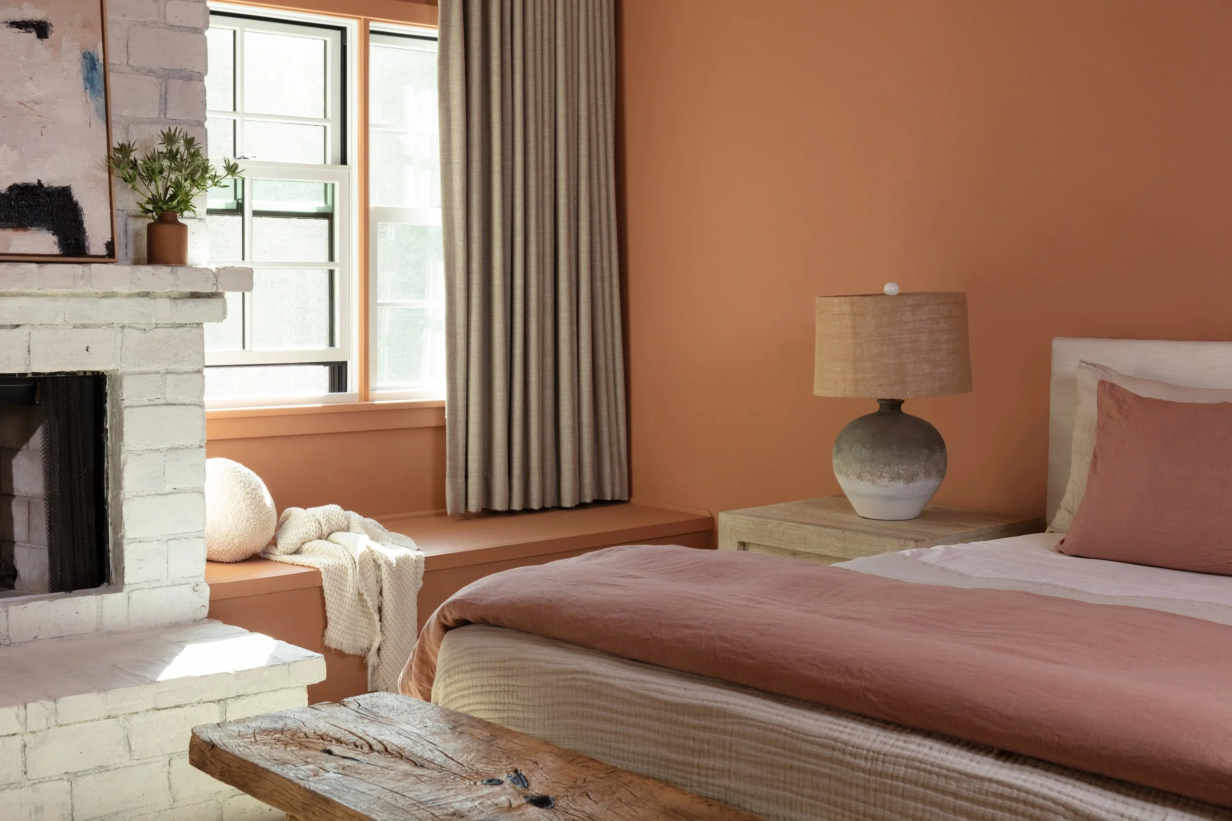 Warm contemporary bedroom with custom window treatments, designer lighting, and natural finishes, completed by JBurton General Contractor in Brentwood, Los Angeles.