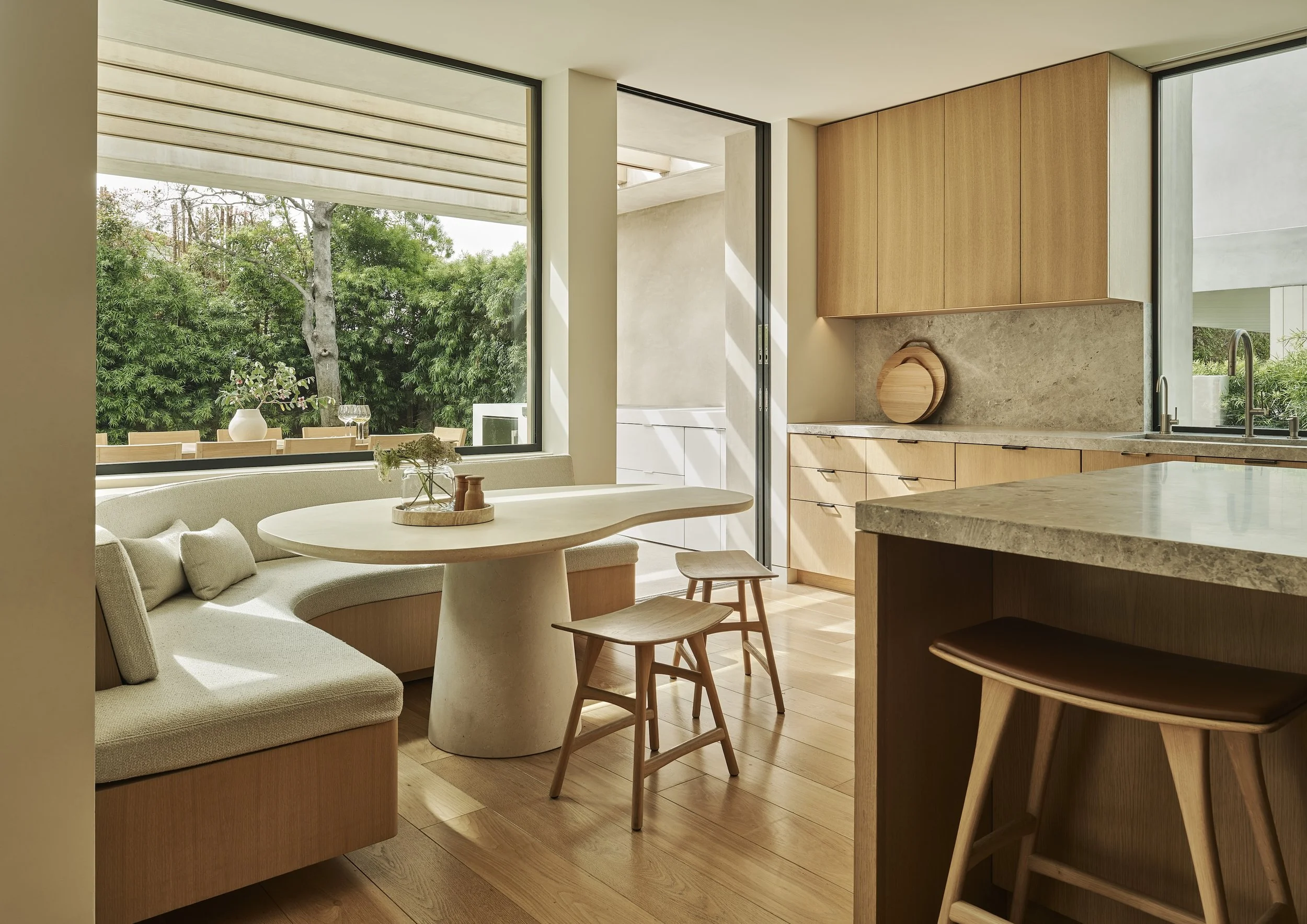 Breakfast nook with built-in banquette seating, large picture windows, and custom wood cabinetry, remodeled by JBurton General Contractor in Beverly Crest, Los Angeles.