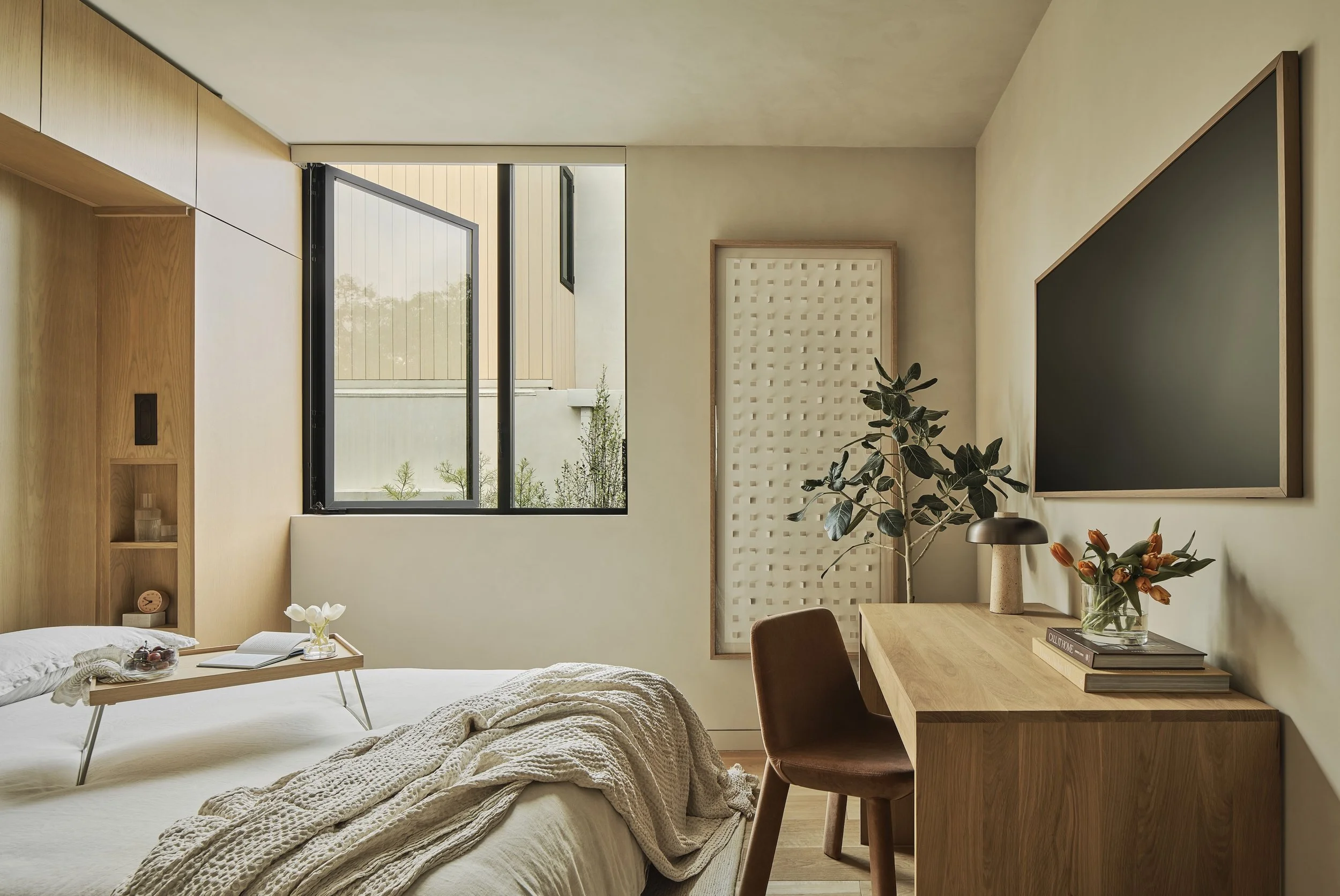 Contemporary secondary bedroom with custom desk, large corner window, and minimalist design, remodeled by JBurton General Contractor in Westwood, Los Angeles.