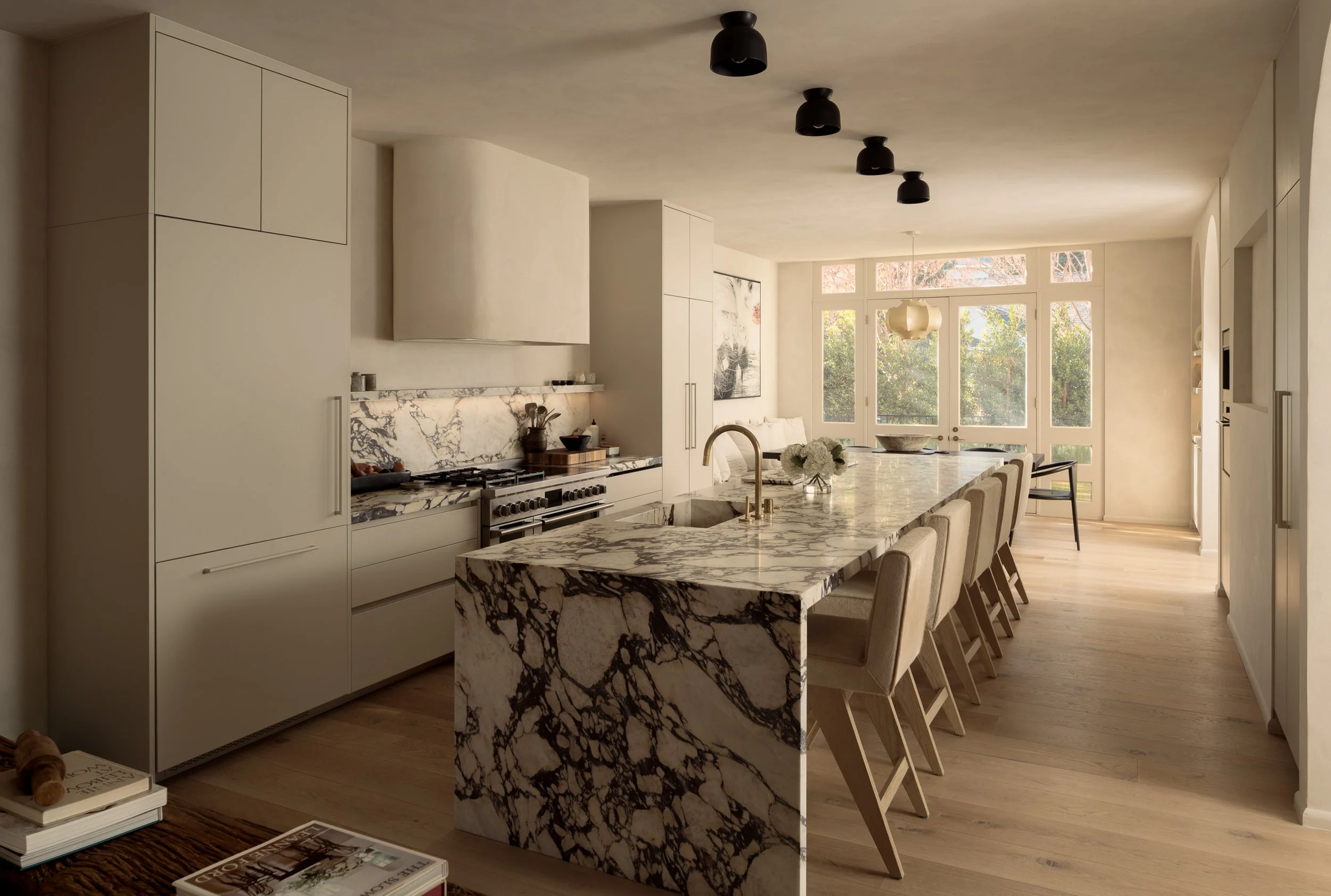 Contemporary kitchen with a dramatic marble waterfall island, custom cabinetry, and open-concept layout, completed by JBurton General Contractor for a luxury home remodel in Benedict Canyon, Los Angeles.