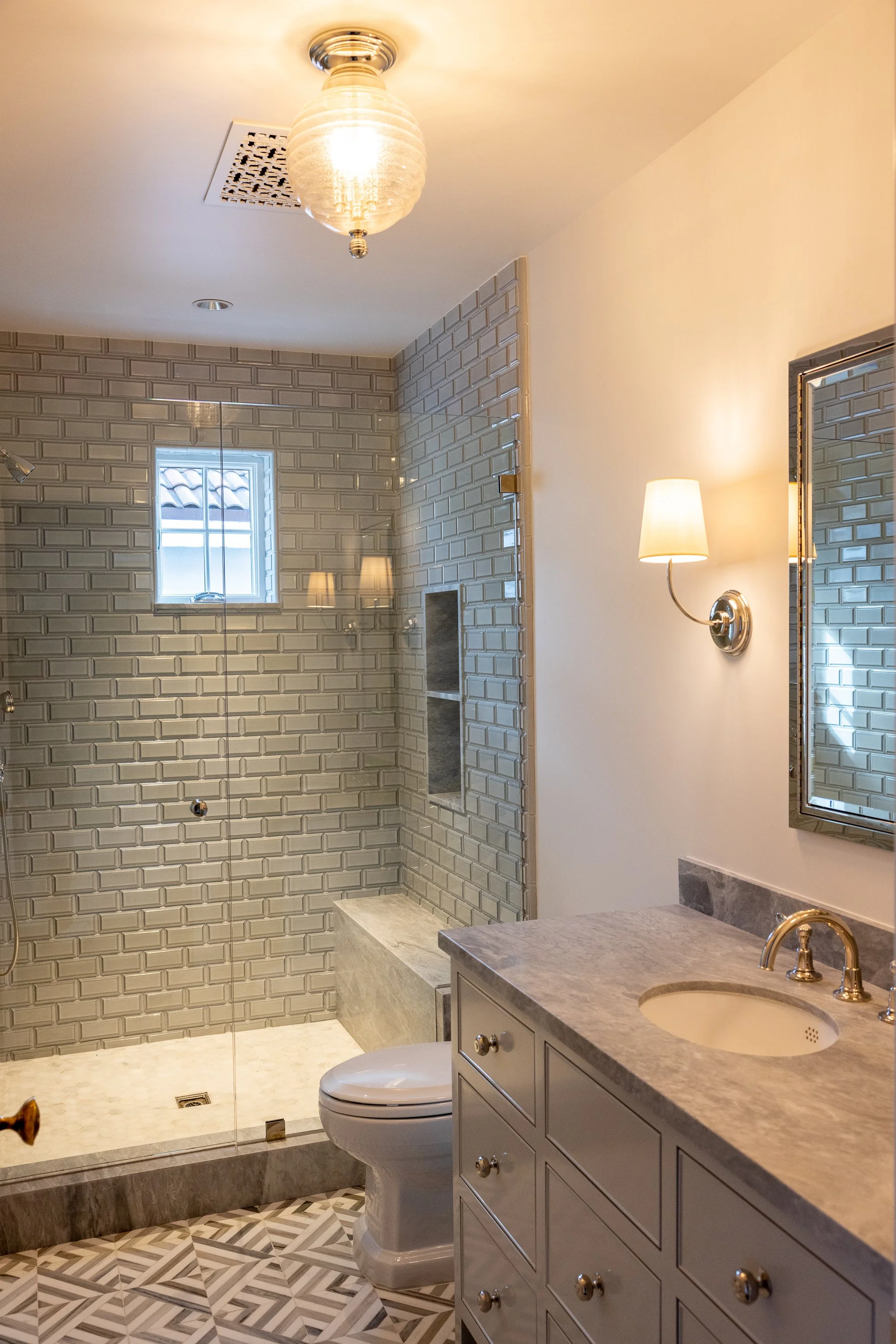Premium shower fixtures set against deep blue handcrafted tile, showcasing the attention to detail of a Hancock Park renovation by JBurton General Contractor.