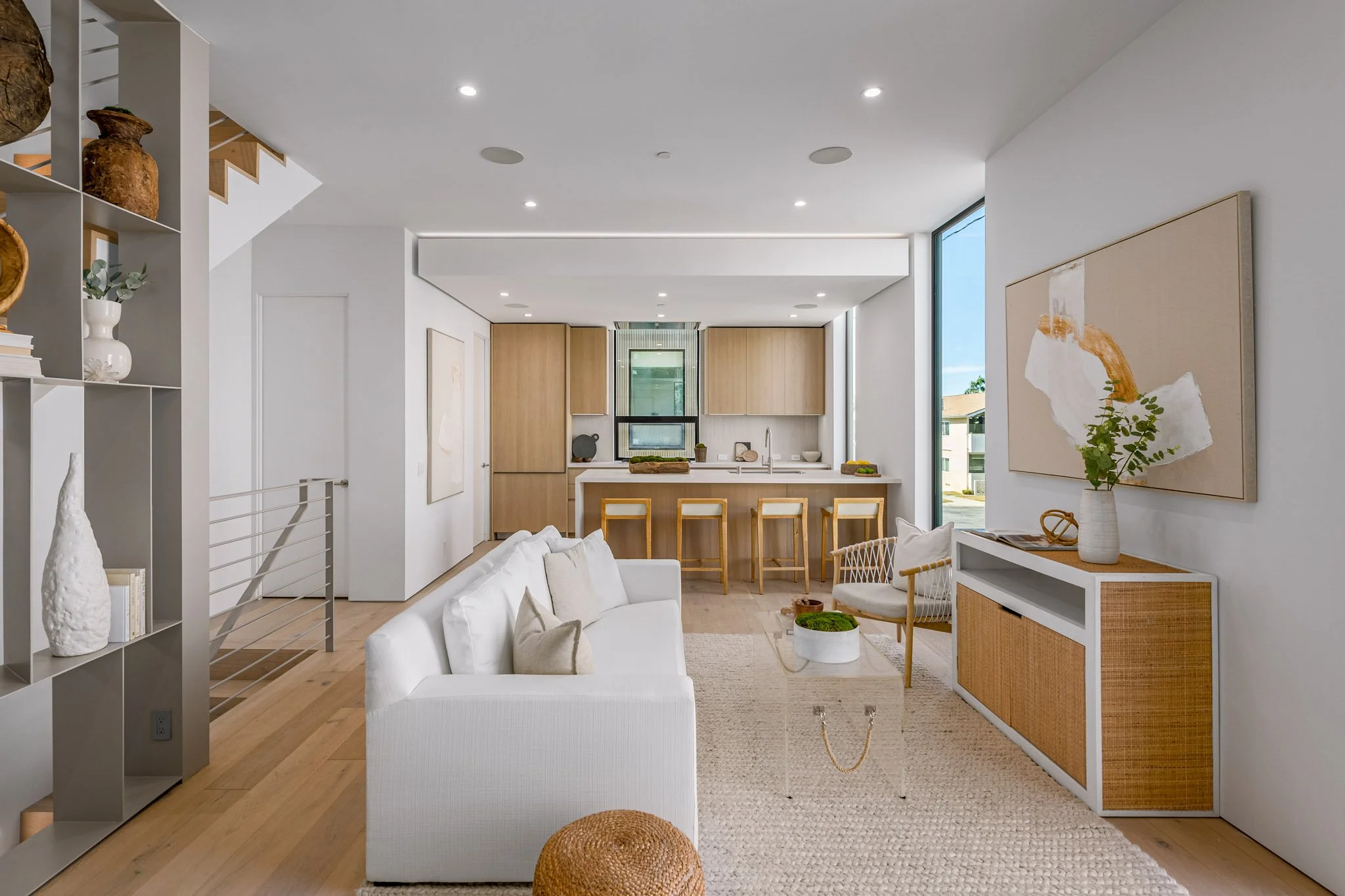 Connected living space designed for everyday comfort, linking the kitchen, dining, and lounge areas with warm wood finishes by JBurton General Contractor.