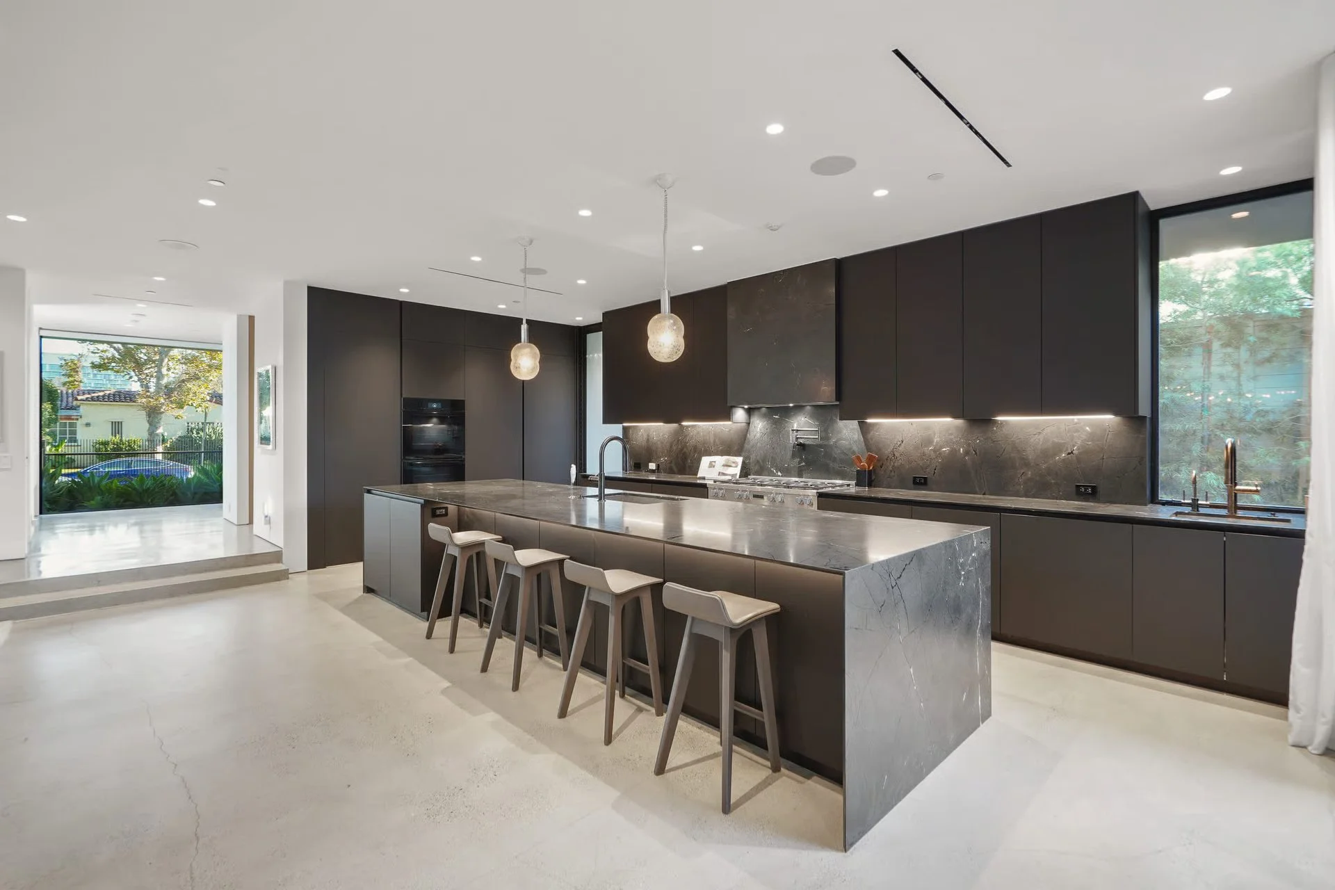 Contemporary kitchen with oversized waterfall island, custom cabinetry, and premium finishes, remodeled by JBurton General Contractor in Beverly Grove, Los Angeles.