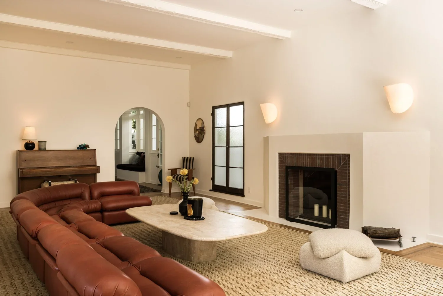 Spanish Revival living room renovation in Los Feliz featuring a restored fireplace, custom plaster walls, and warm contemporary furnishings.