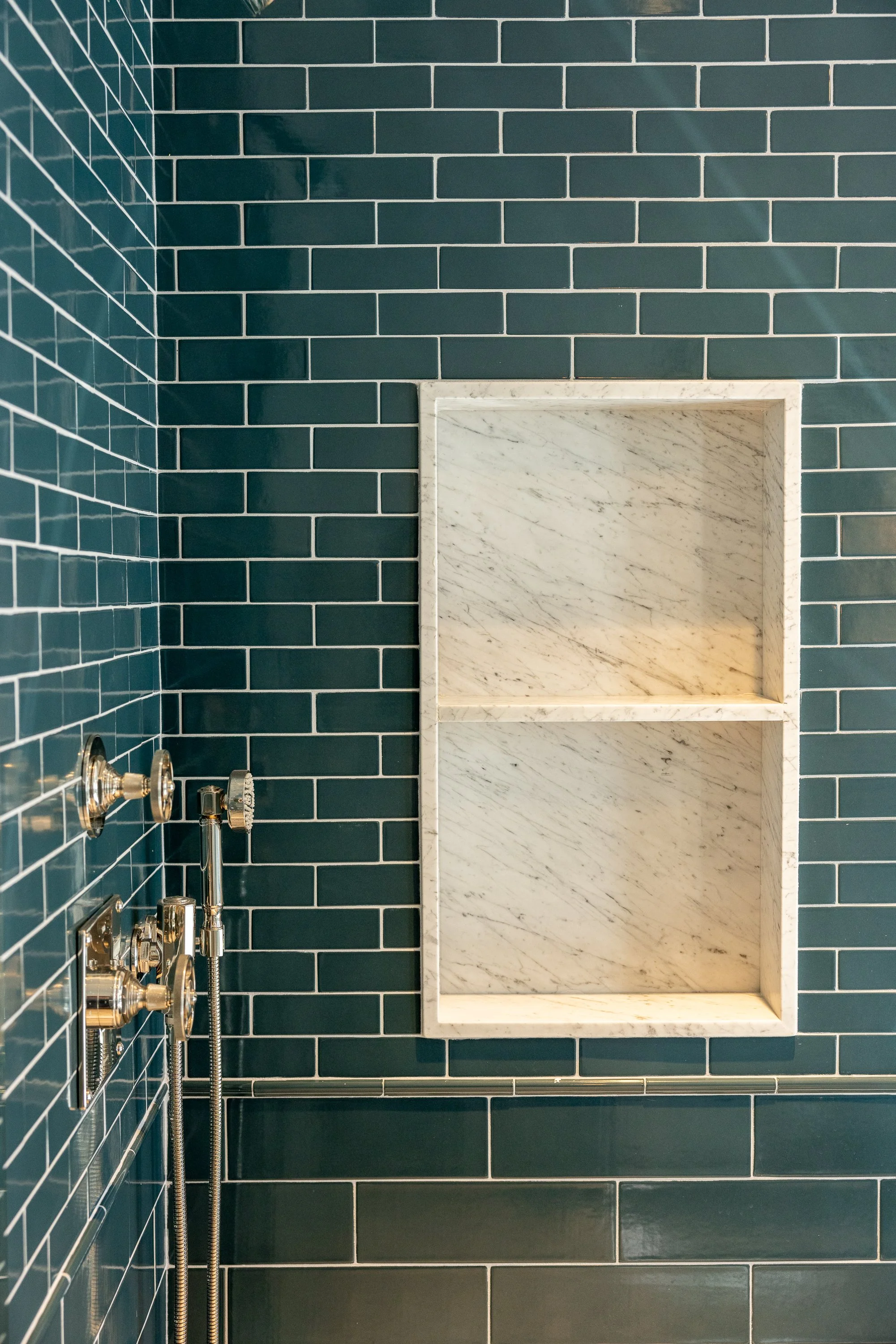 Walk-in shower with rich ceramic tile, custom marble niche, and luxury plumbing fixtures by JBurton General Contractor in Hancock Park, Los Angeles.