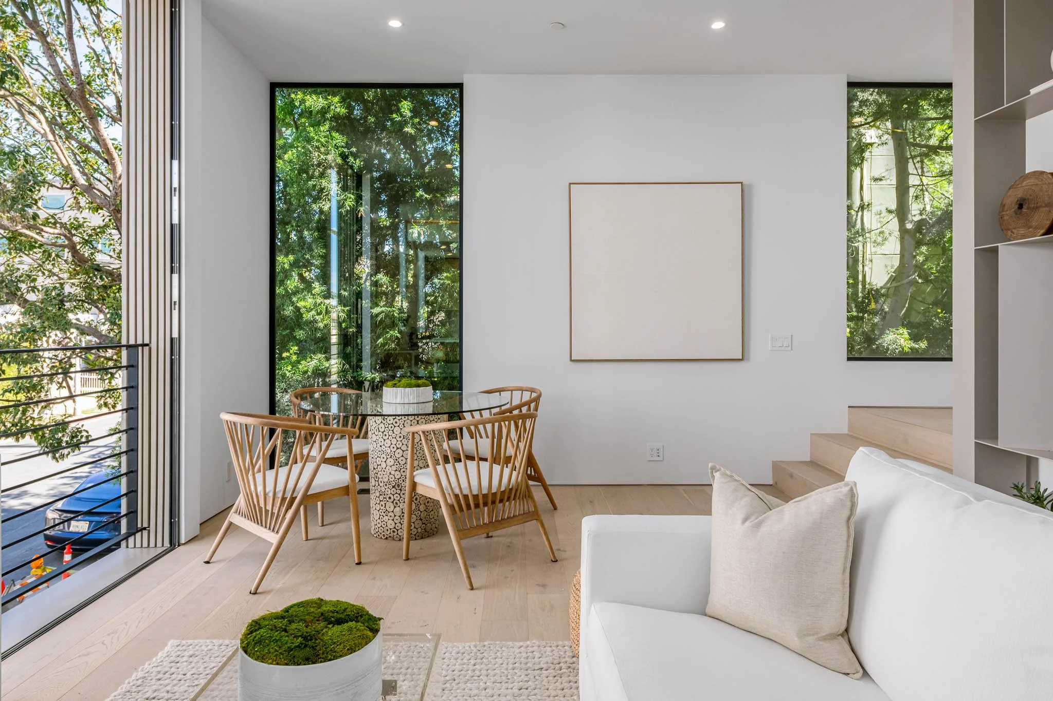 Cozy dining area framed by floor-to-ceiling windows that bring abundant natural light into this thoughtfully designed home by JBurton General Contractor.