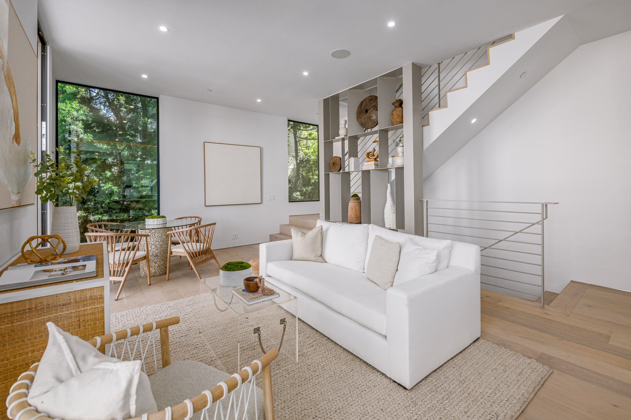 Open-plan living area connecting the kitchen, dining space, and custom staircase with bright, functional interiors by JBurton General Contractor.
