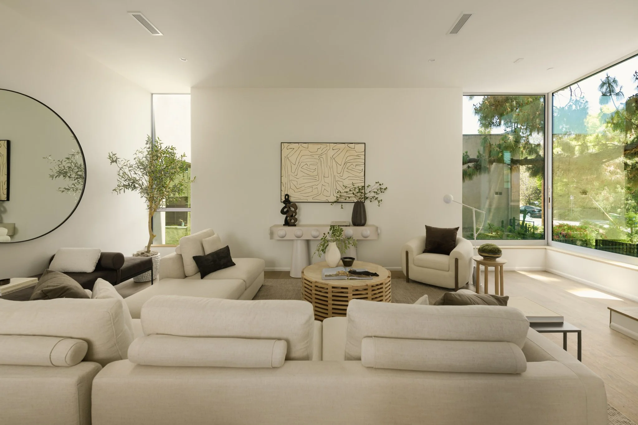 Open-concept living room with floor-to-ceiling windows, contemporary furnishings, and abundant natural light, built by JBurton General Contractor for luxury townhomes in Silver Lake, Los Angeles.