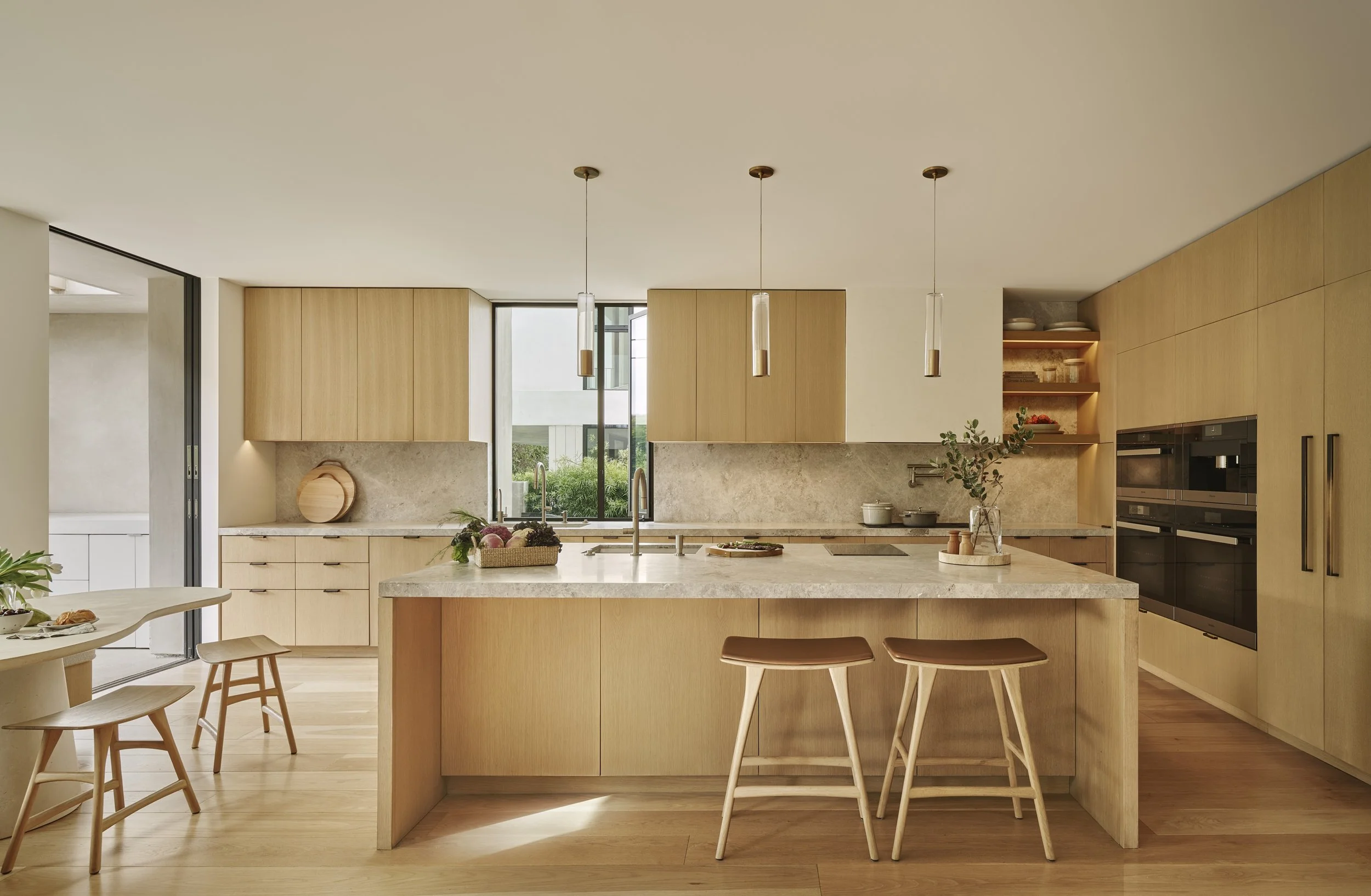 Custom kitchen with a waterfall island, natural wood cabinetry, and modern pendant lighting, remodeled by JBurton General Contractor in Beverly Crest, Los Angeles.