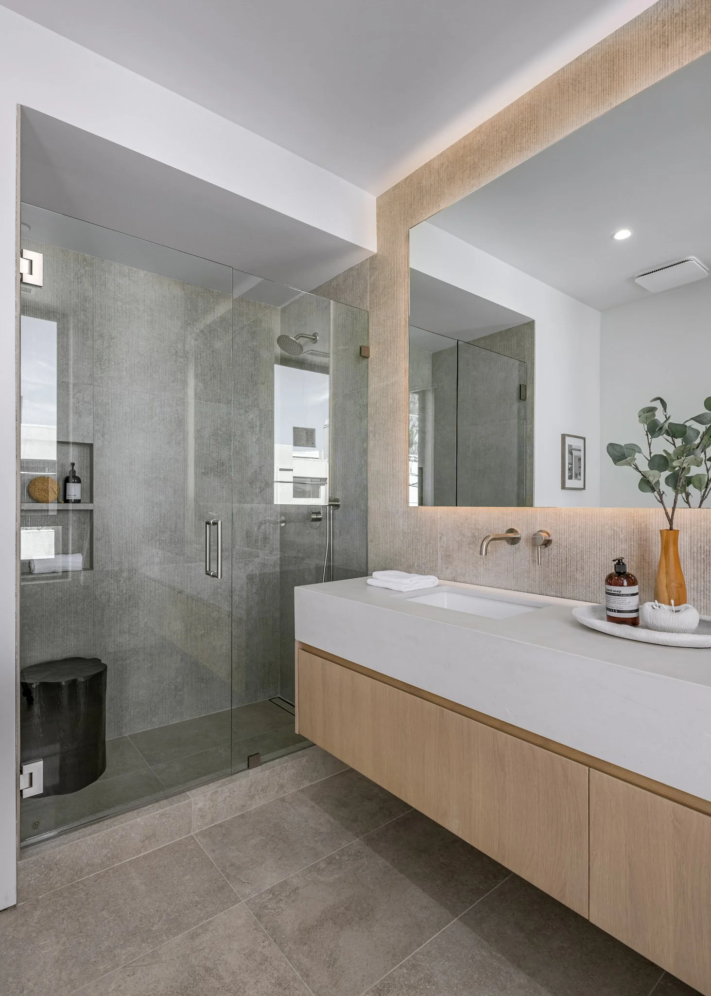 Primary bathroom retreat featuring a floating oak vanity, frameless glass shower, and clean contemporary finishes crafted by JBurton General Contractor.