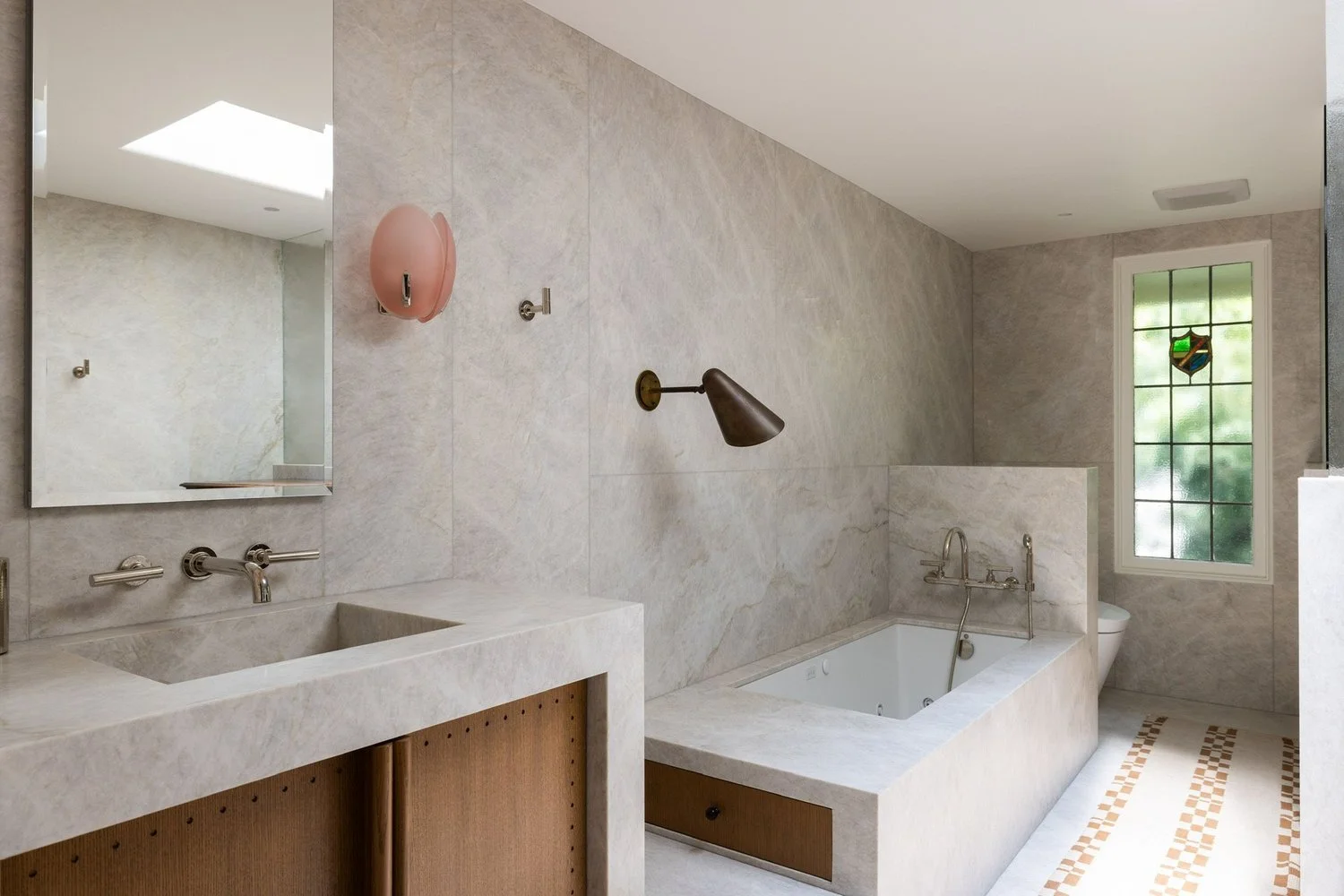 Luxury primary bathroom with natural stone finishes, integrated vanity, soaking tub, and custom cabinetry in a renovated Los Feliz Spanish Revival home.