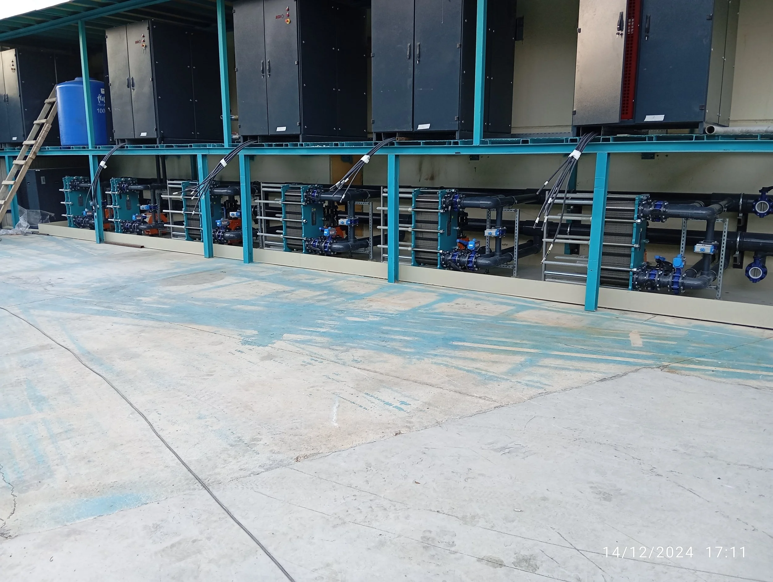 Endüstriyel soğutma veya su pompa sistemi. Metal borular ve kontrol valfleri ile donatılmış ekipmanlar yer alıyor.