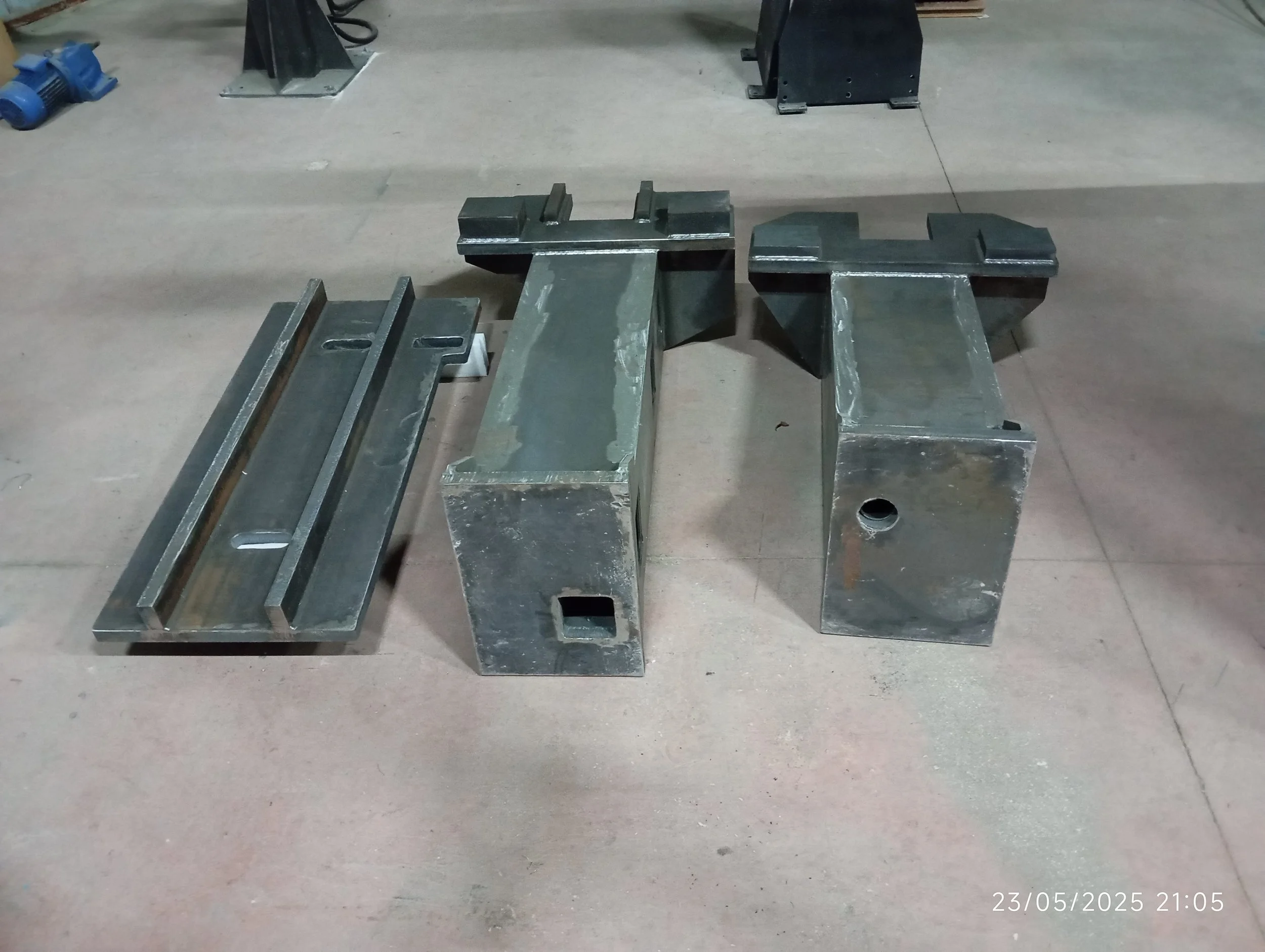 İki büyük metal parça ve bir metal parça plakası, fabrikada kullanılmak için hazırlanmış gibi görünüyor.