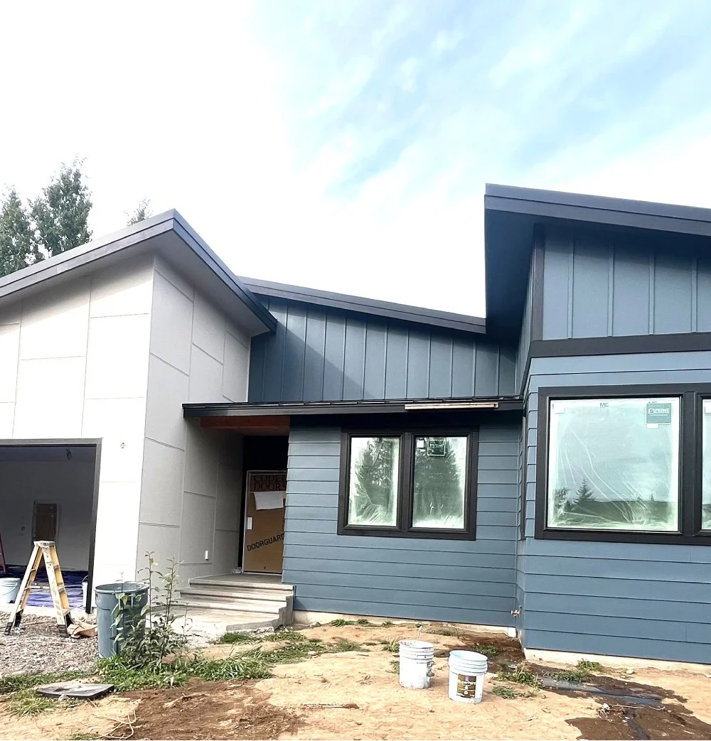 Newly remodeled two-story home with gray vertical siding and white trim