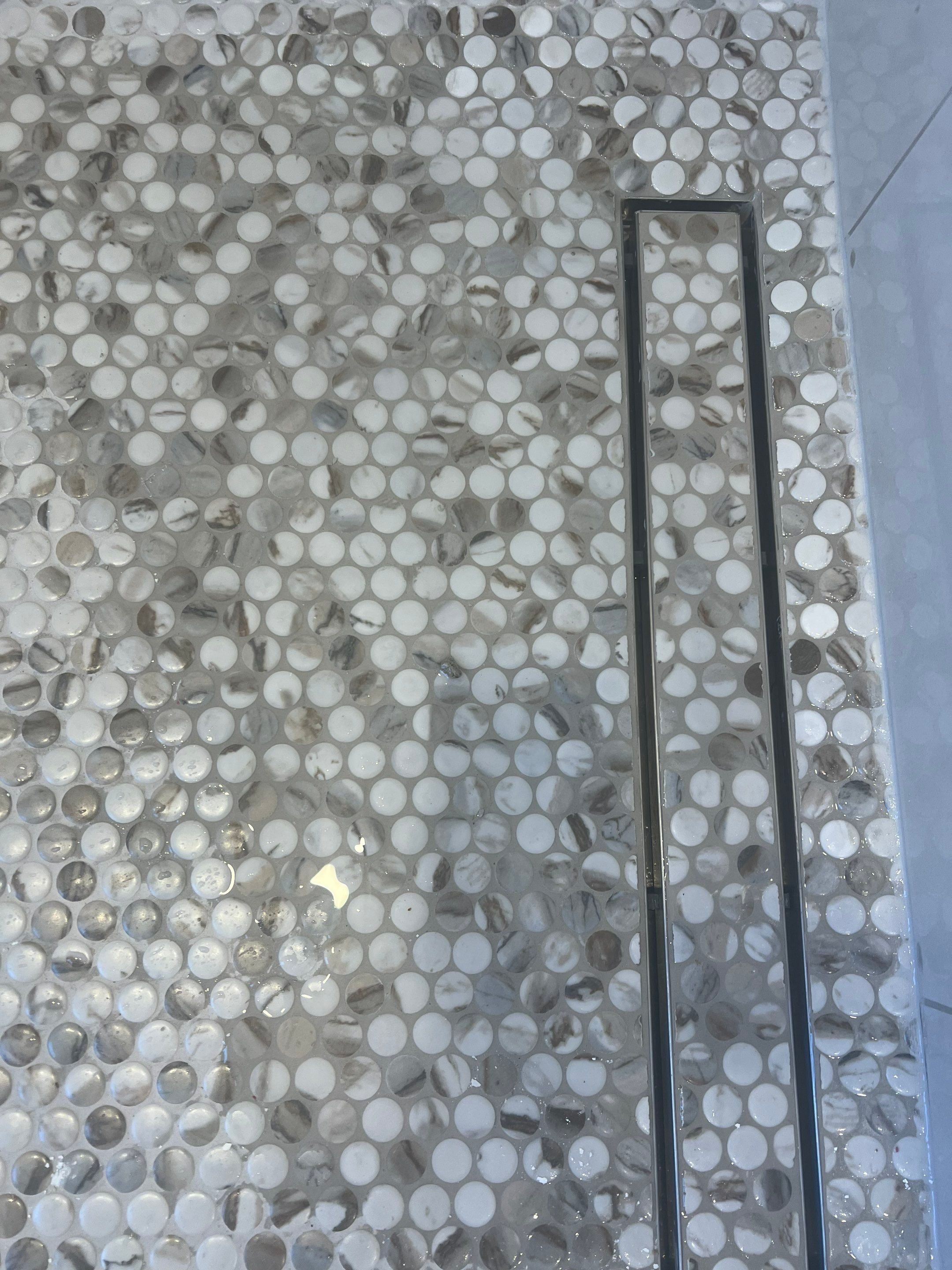 Primary bath shower renovation with stone-looking porcelain tile in vertical stack installation pattern with in-shower bench and towel hooks, frameless shower glass, rain shower system and penny tile floor with tile-in linear drain
interior designer 