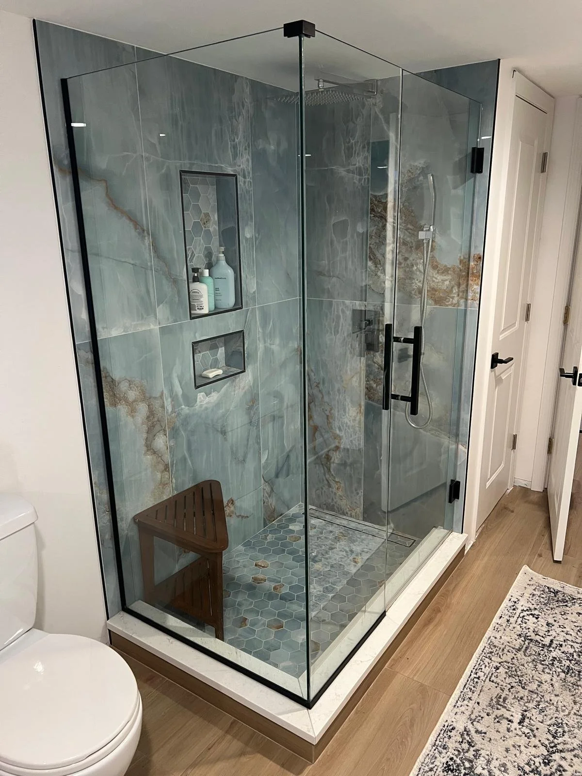 standing shower with blue marbled porcelain tile and recessed niches, quartz step, chrome shower system, frameless shower glass with black hardware
Interior Designer - Chicago
interior design chicago
kitchen designer chicago
bathroom designer chicago