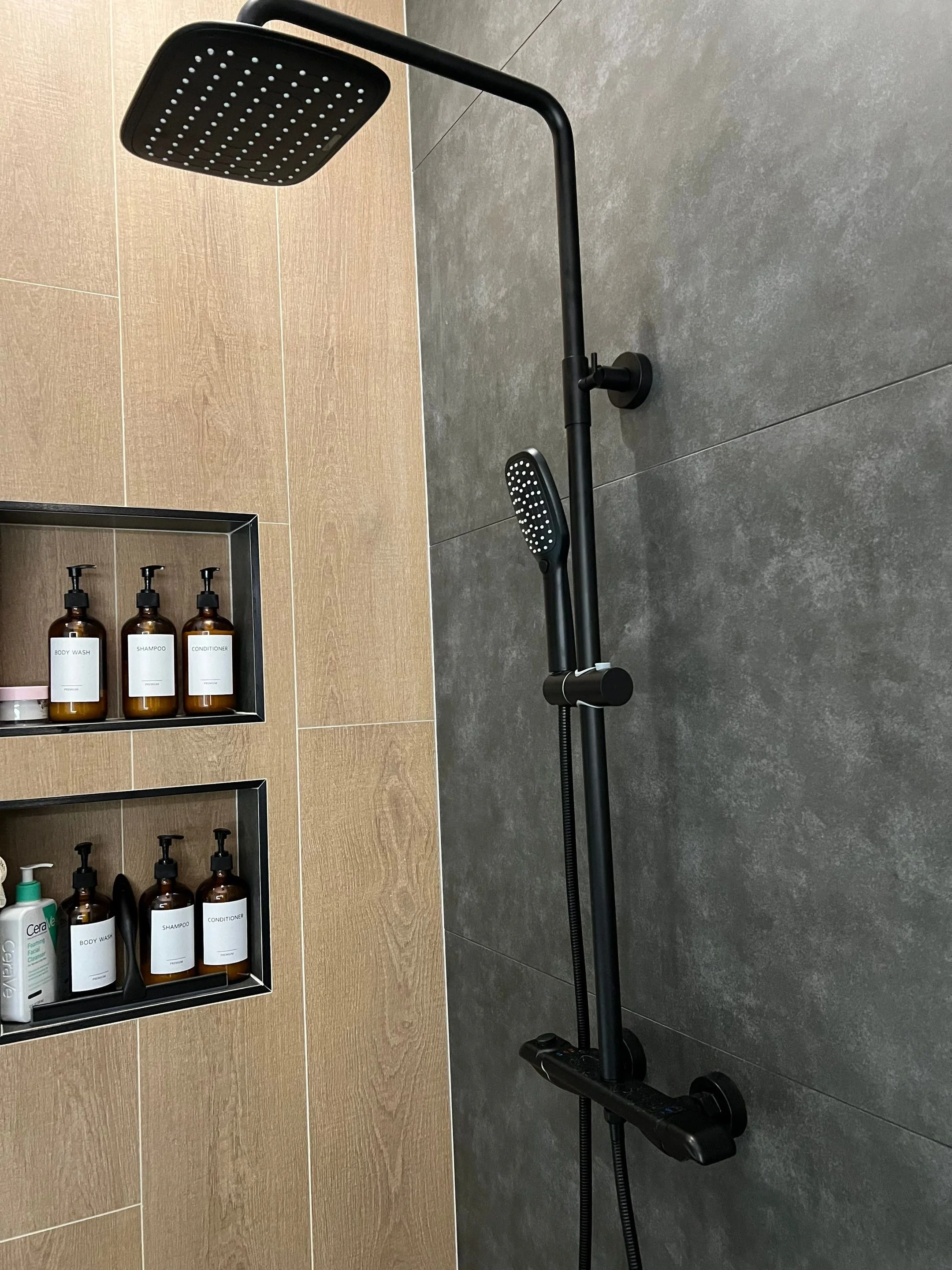 primary bath interior design with large format tile in wood-look pattern and cement color, freestanding bathtub, recessed niches wtih lighting, seamless shower with hidden drain, rain shower system, floating vanity, LED lit mirror, vaulted ceiling
in