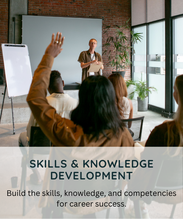 A person is giving a presentation to a small group of people in a modern, well-lit room with large windows and potted plants. One person in the audience has their hand raised.