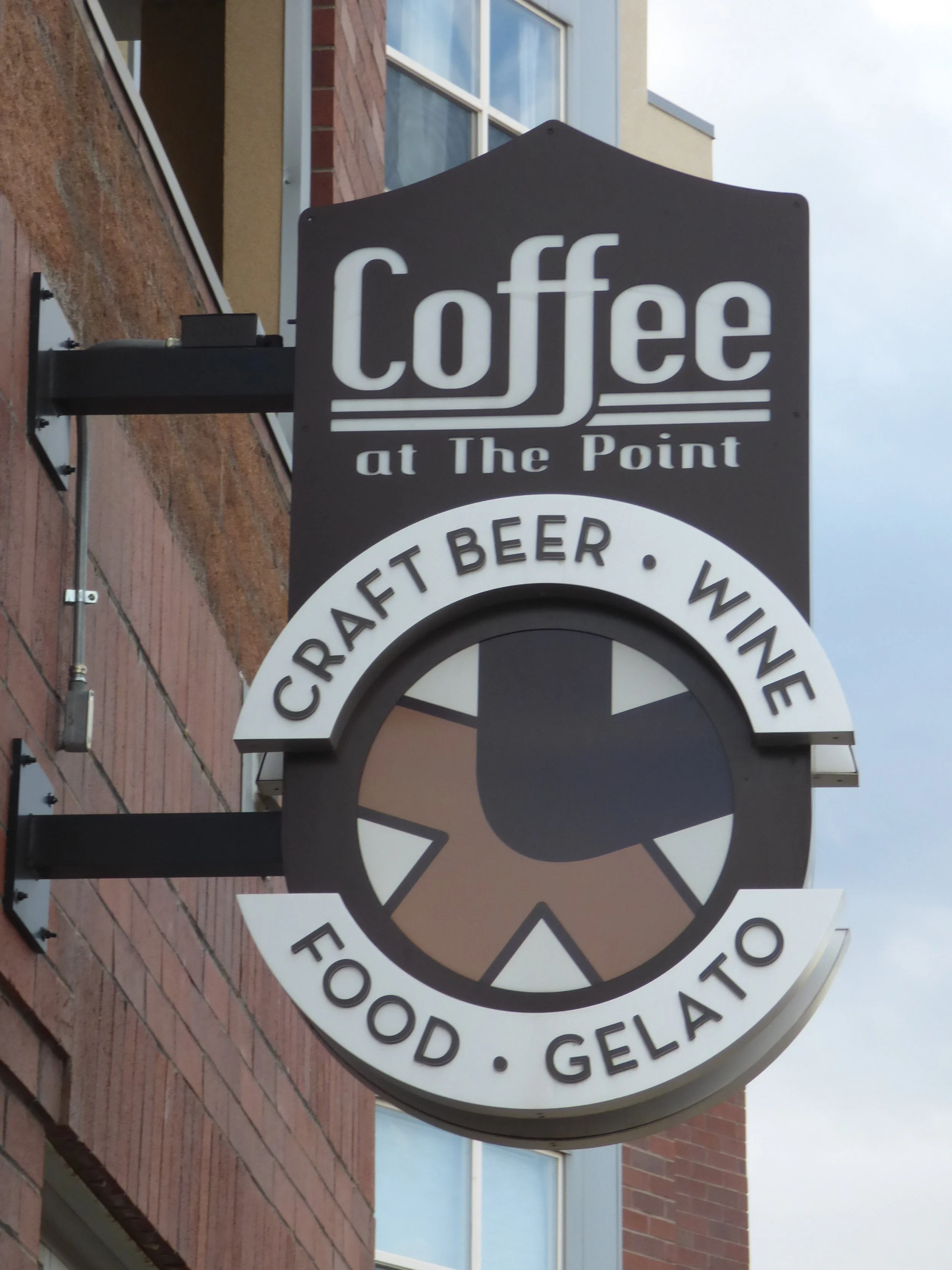 A black and white outdoor sign for a coffee shop called 'Coffee at The Point,' also offering craft beer, wine, food, and gelato at Fifth Coffee House, Denver, CO 80205.