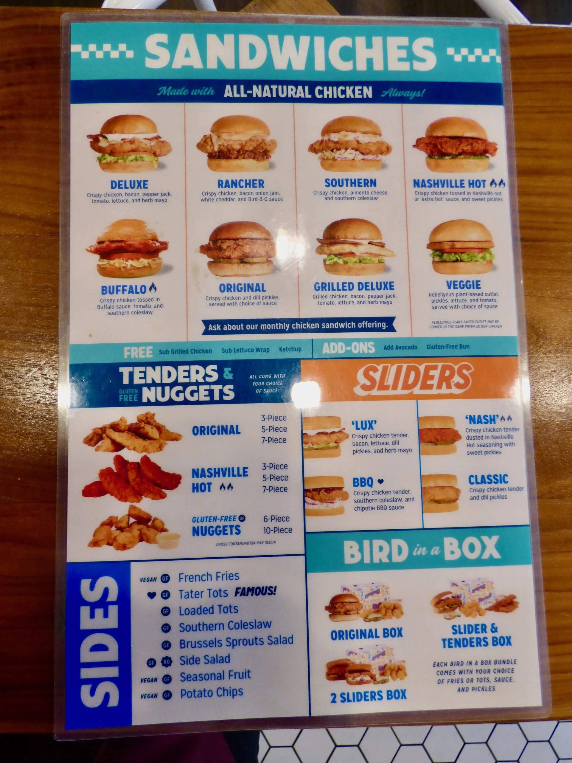 Menu featuring various chicken sandwiches, tenders, and sides at a fast food restaurant.