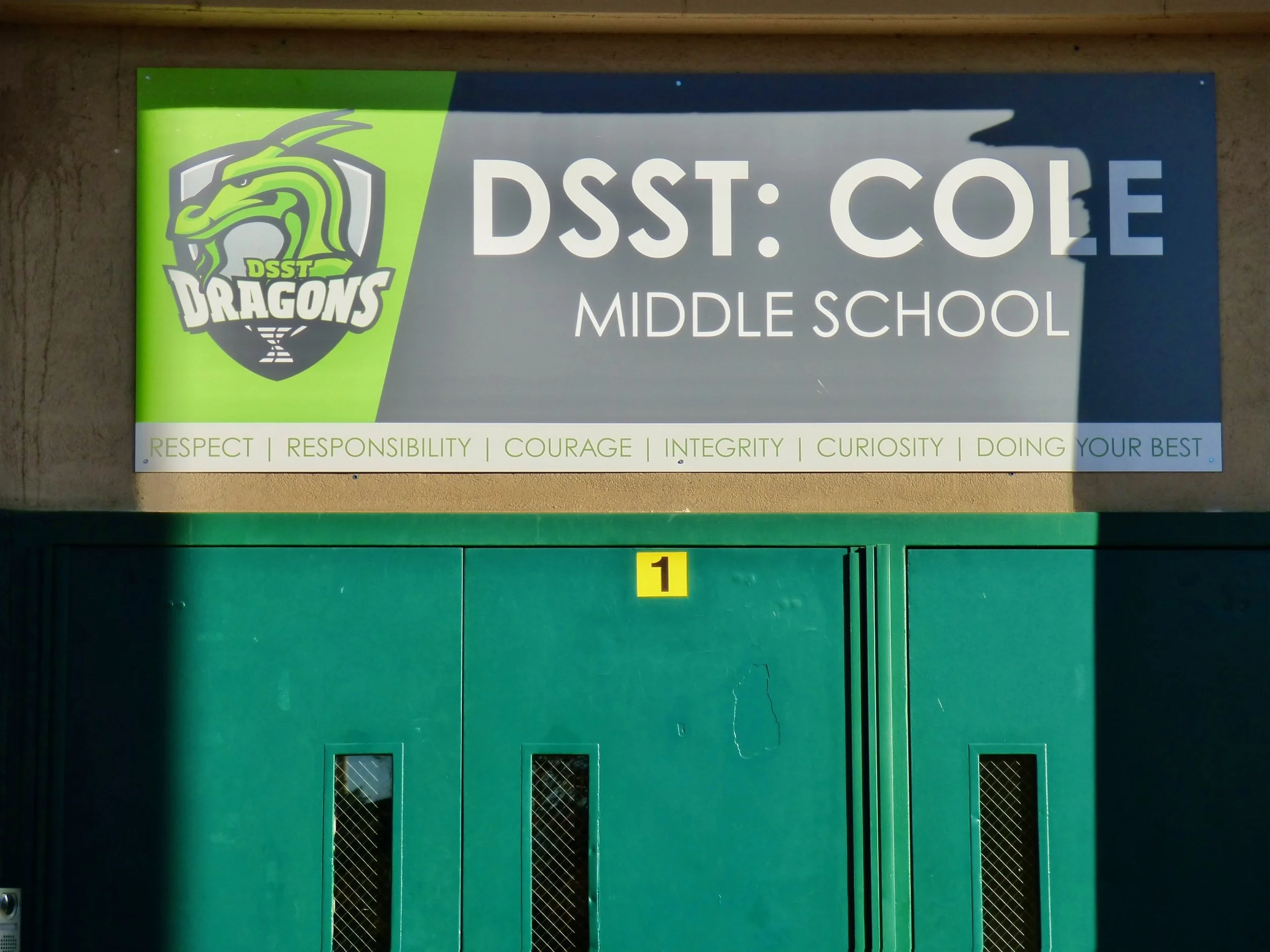 Sign for DSST: Cole Middle School with school motto and mascot logo