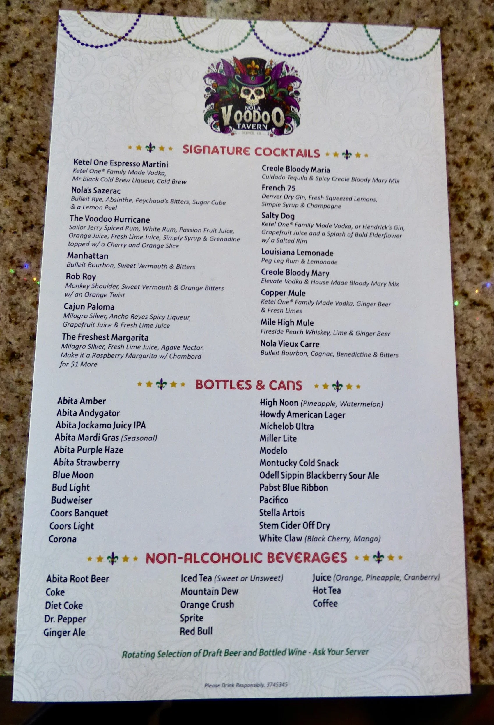 Menu from the Voodoo Tavern featuring signature cocktails, bottled and canned beverages, and non-alcoholic drinks.Signature cocktails include Ketel One Espresso Martini, Nola's Sazerac, and The Voodoo Hurricane at NOLA Voodoo Tavern, Denver, CO 80205