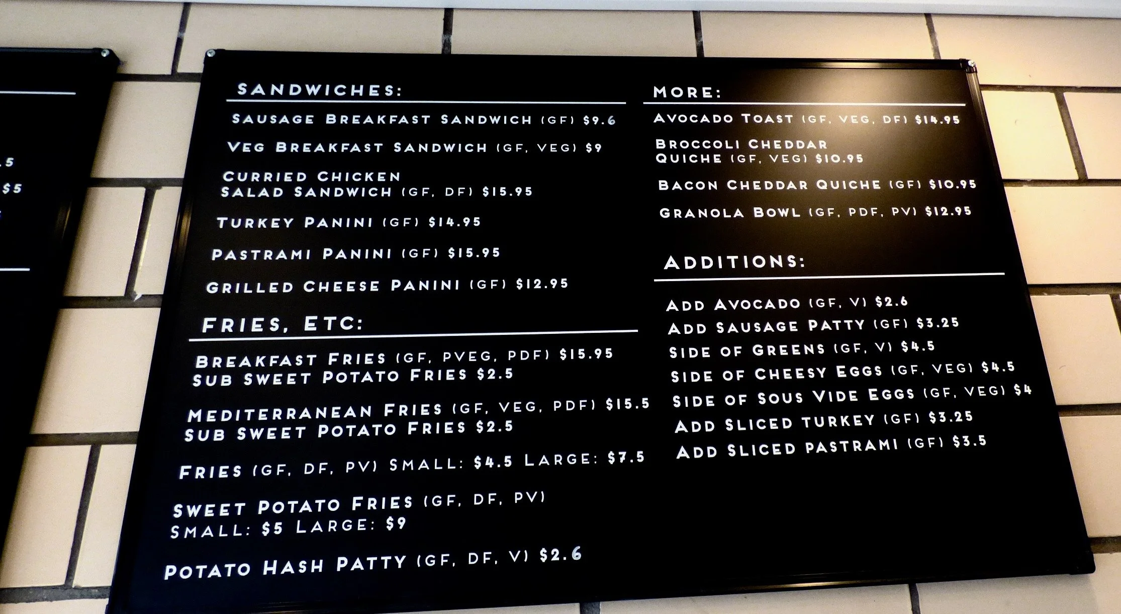 Restaurant menu board displaying options for sandwiches, fries, and more, with prices listed.