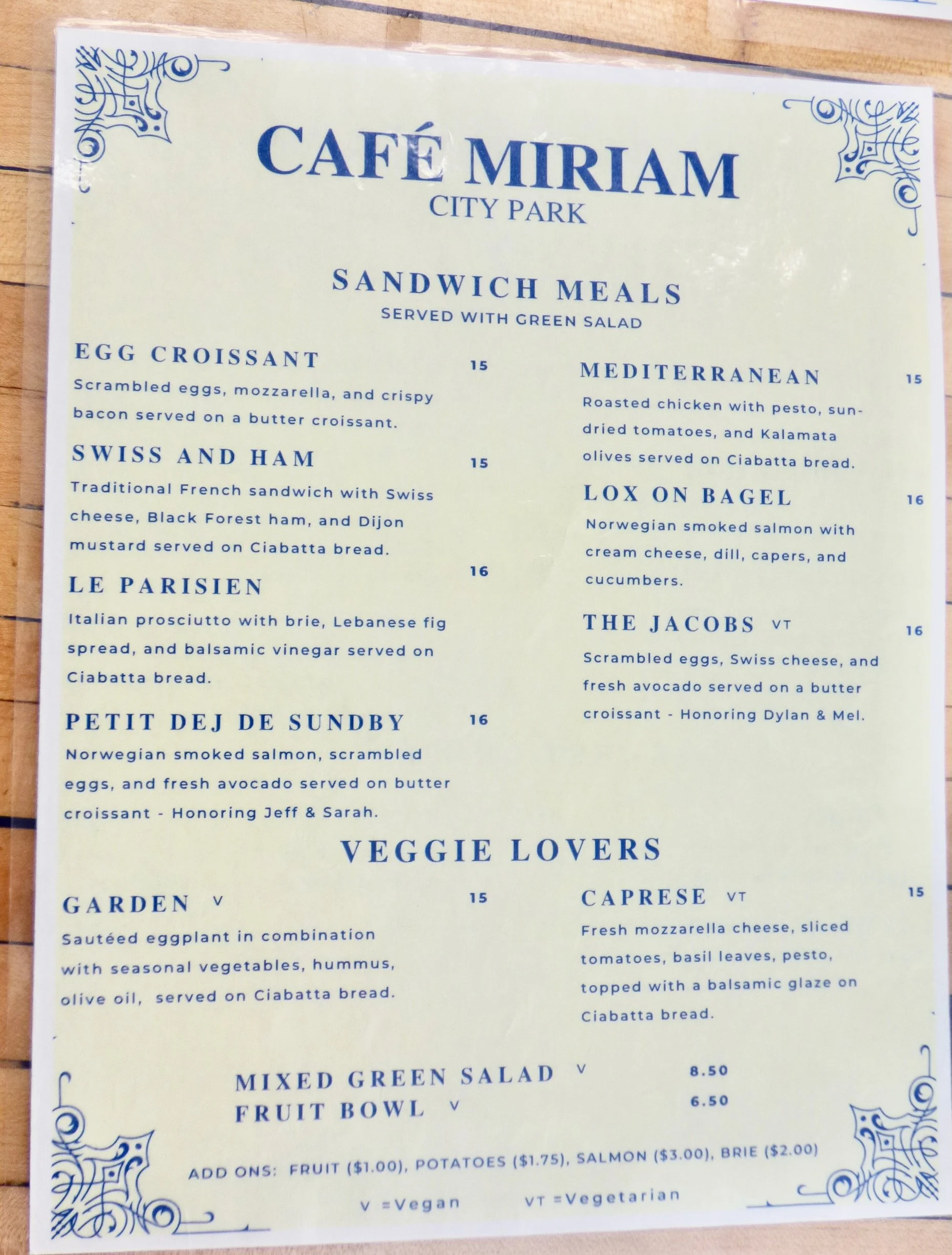 Menu from Café Miriam City Park listing sandwich meals, veggie options, salads, and add-ons.