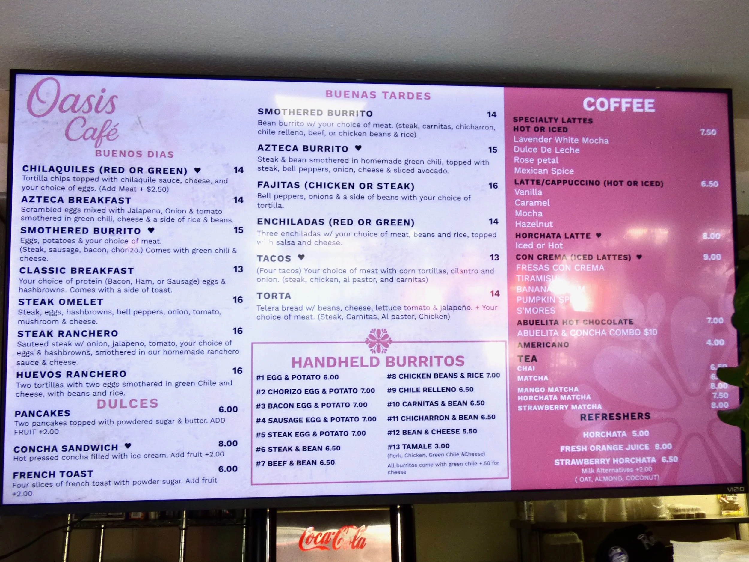 Menu board at Oasis Cafe with food and drink options including breakfast, burritos, tacos, hot and iced coffee, and desserts, all listed with prices at Oasis Cafe & Grill, Denver, CO 80205.