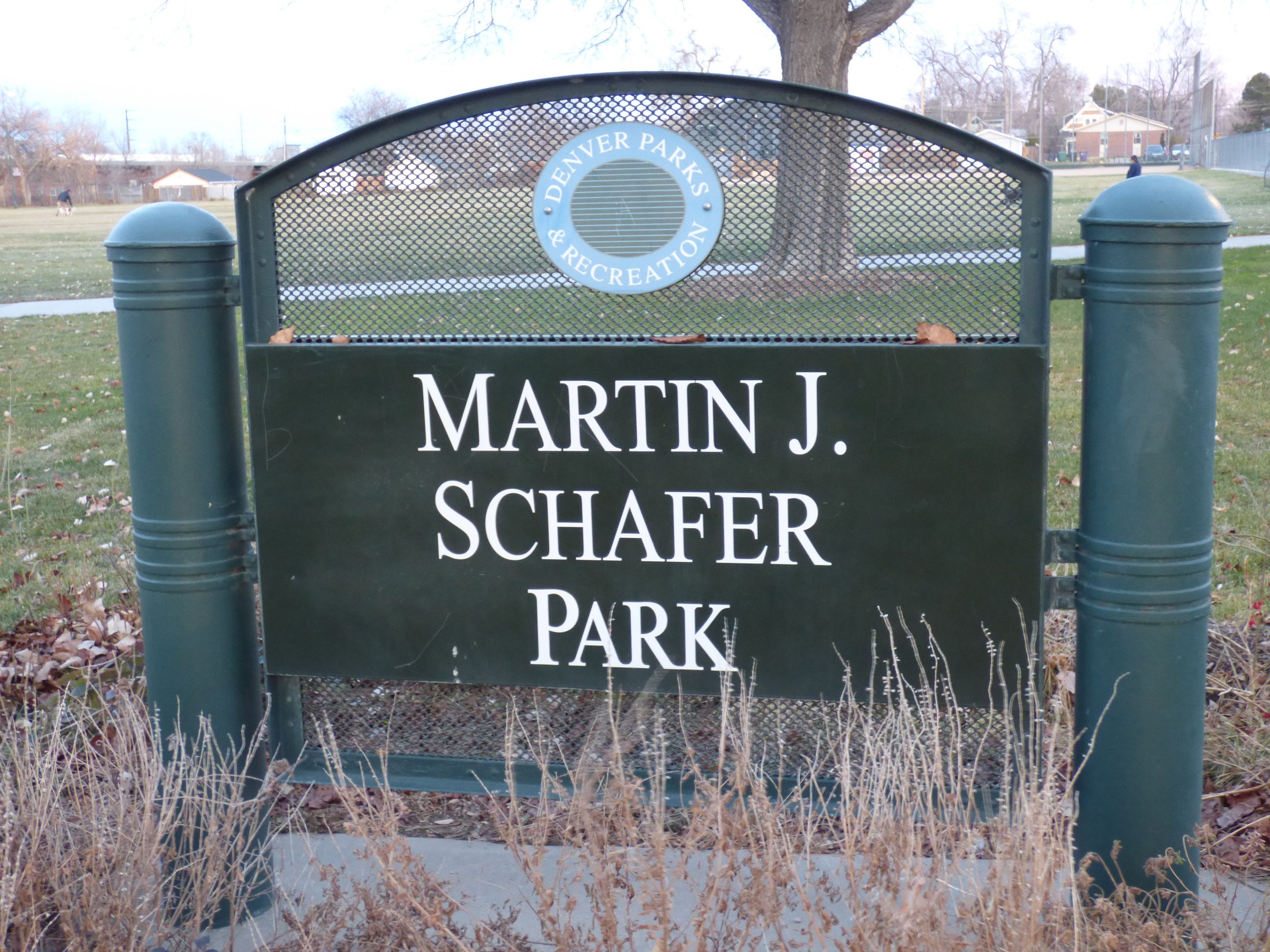 Sign for Martin J. Schafer Park in Denver, Colorado, featuring the Denver Parks & Recreation emblem, with grass and trees in the background in Martin J. Schafer Park, Denver, CO 80205.