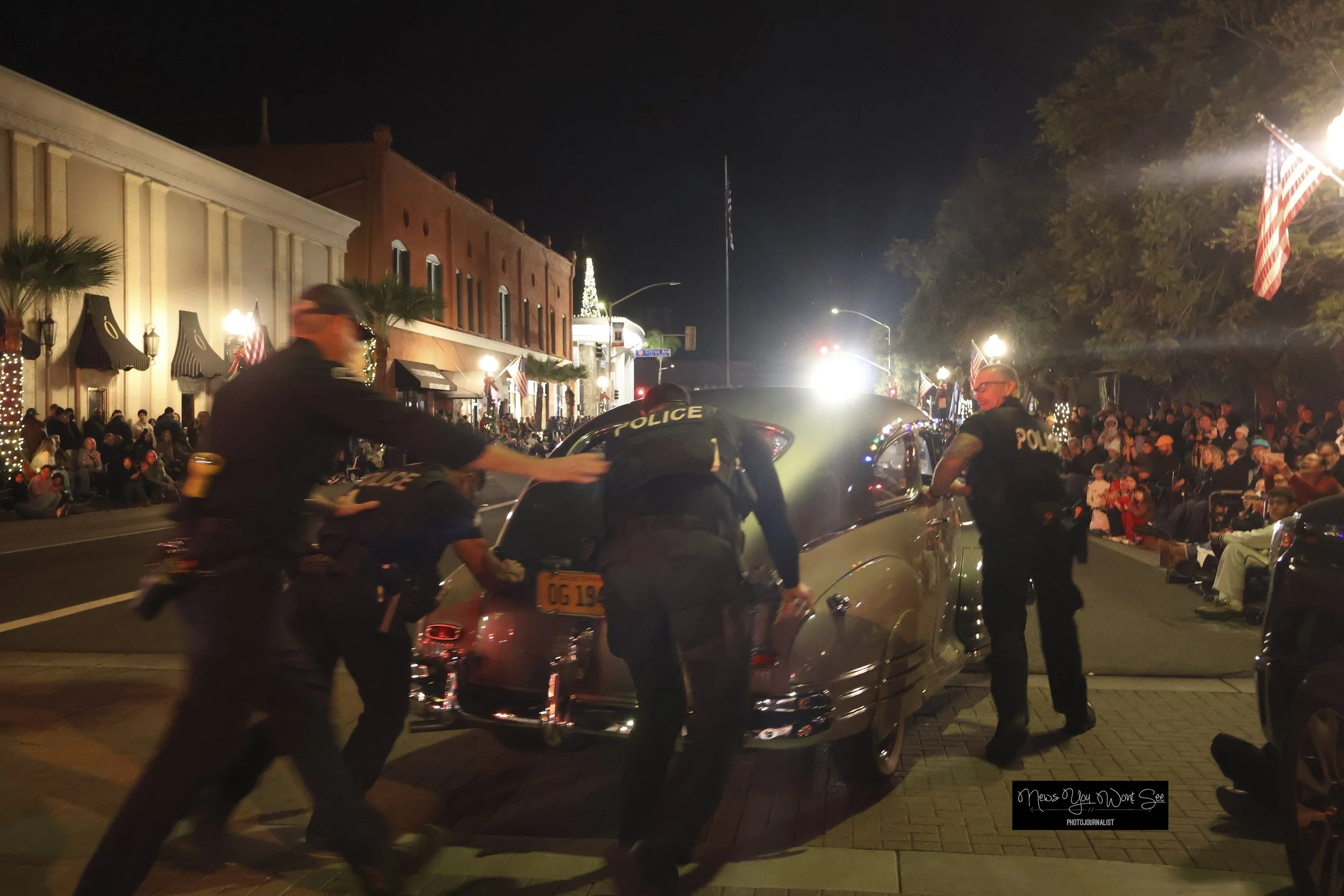  Members of the Redlands Police helped move a car that stalled during the annual Christmas parade hosted by the Kiwanis Club of Redlands on Saturday, Dec. 6, 2025. (Photo by Brian Spears, Redlands Collective News) 