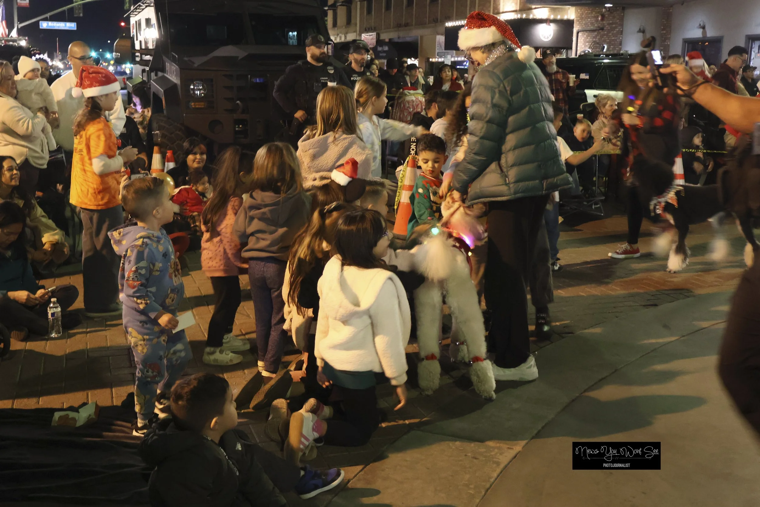  Kids pet a dog during the annual Christmas parade hosted by the Kiwanis Club of Redlands on Saturday, Dec. 6, 2025. (Photo by Brian Spears, Redlands Collective News) 
