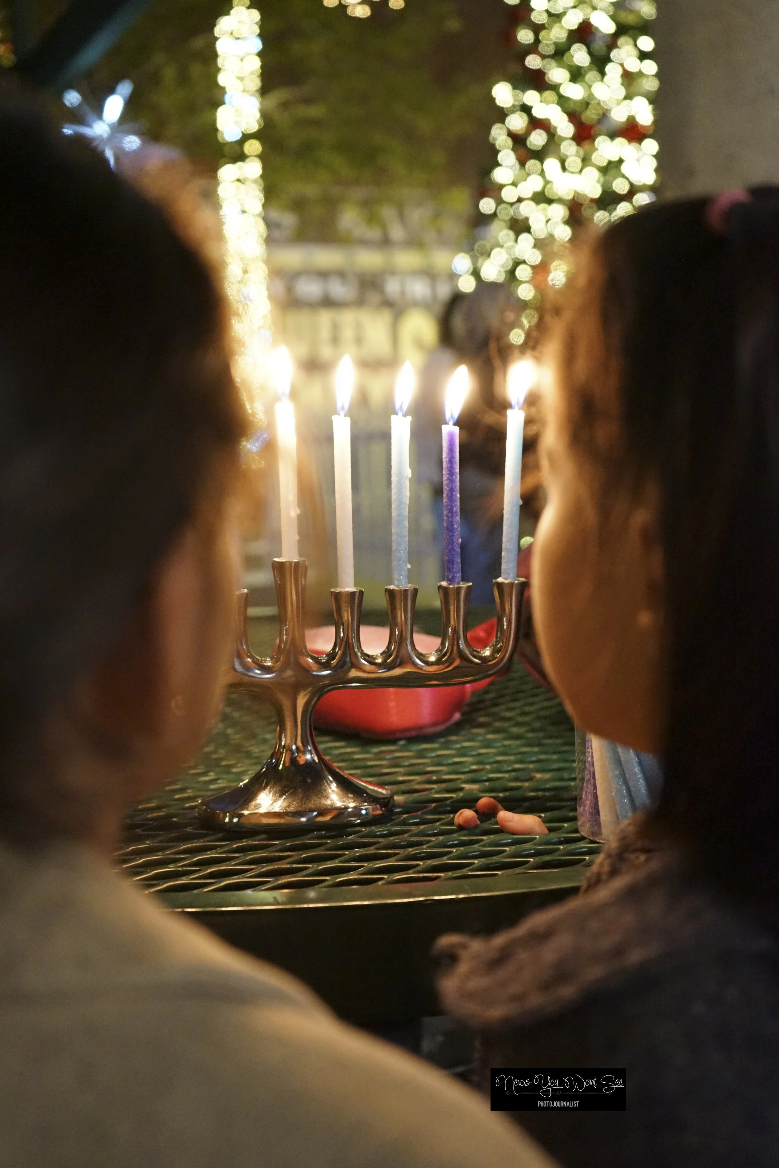  Mica, 9, and Gabi En Gad, 8, observe their menorah during the Light Up the Night event at Ed Hales Park in Redlands, Dec. 20, 2025 (Photo by Brian Spears, Redlands Collective News) 