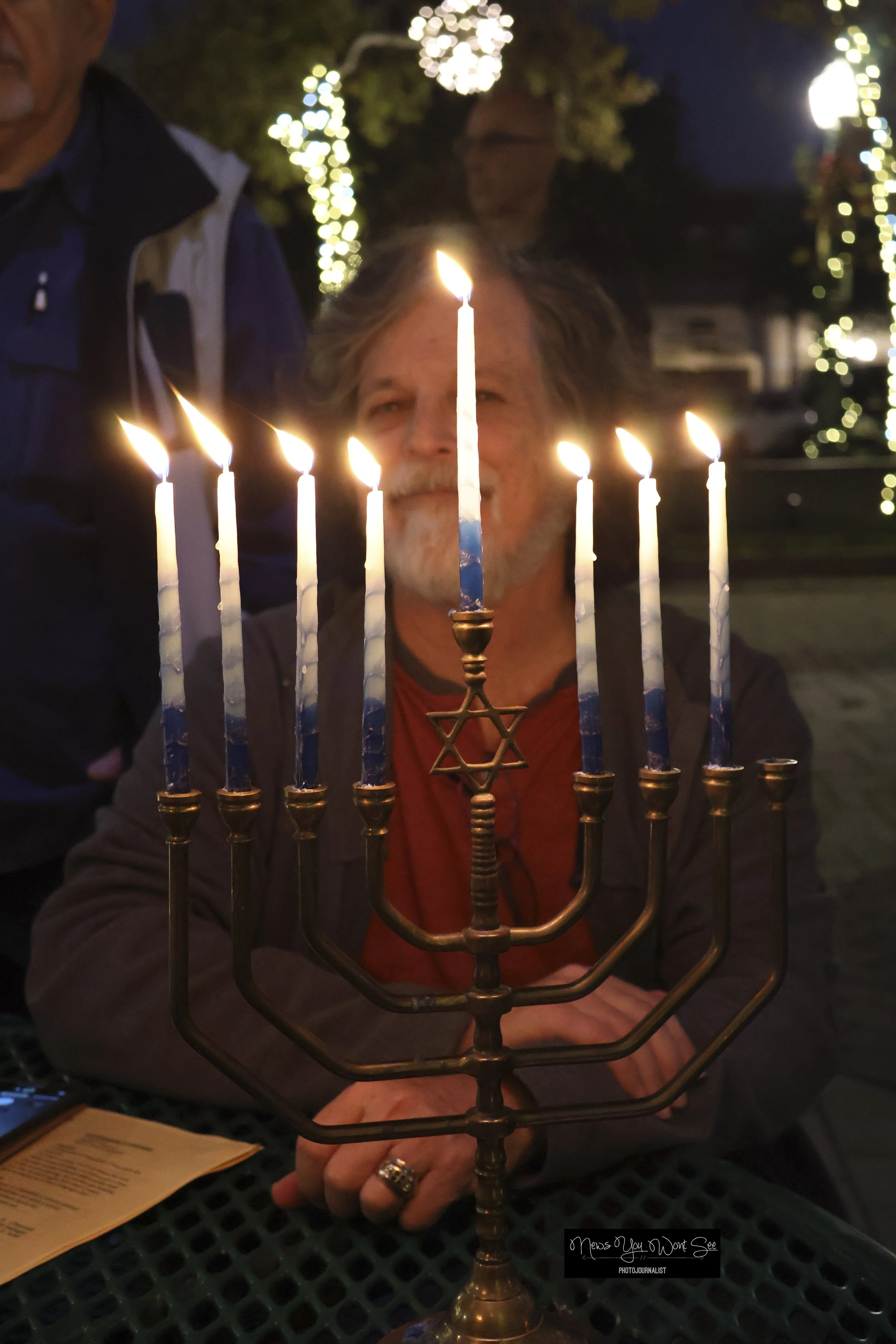  Kerry Wolk looks at the menorah at the Light Up the Night event at Ed Hales Park in Redlands, Dec. 20, 2025 (Photo by Brian Spears, Redlands Collective News) 