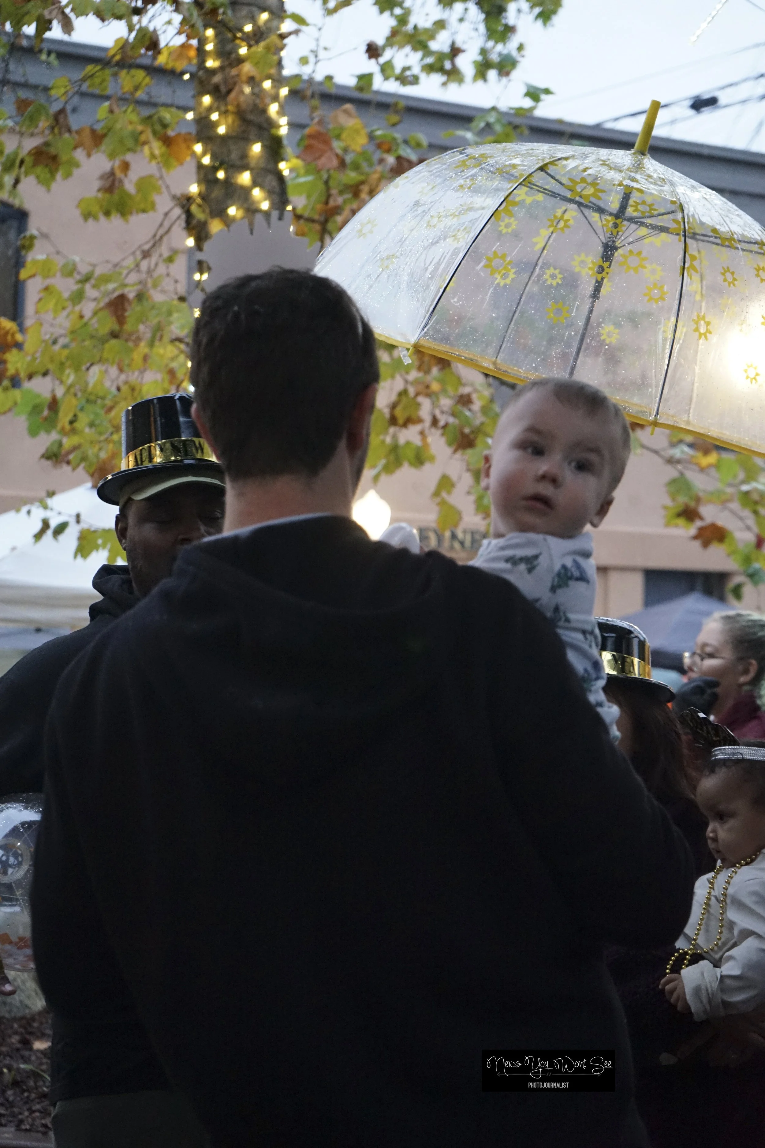  A child smiles on their father’s arms as people enjoy at the annual beach ball drop at Ed Hales Park, Dec. 31, 2025. (photo by Brian Spears, Redlands Collective News) 