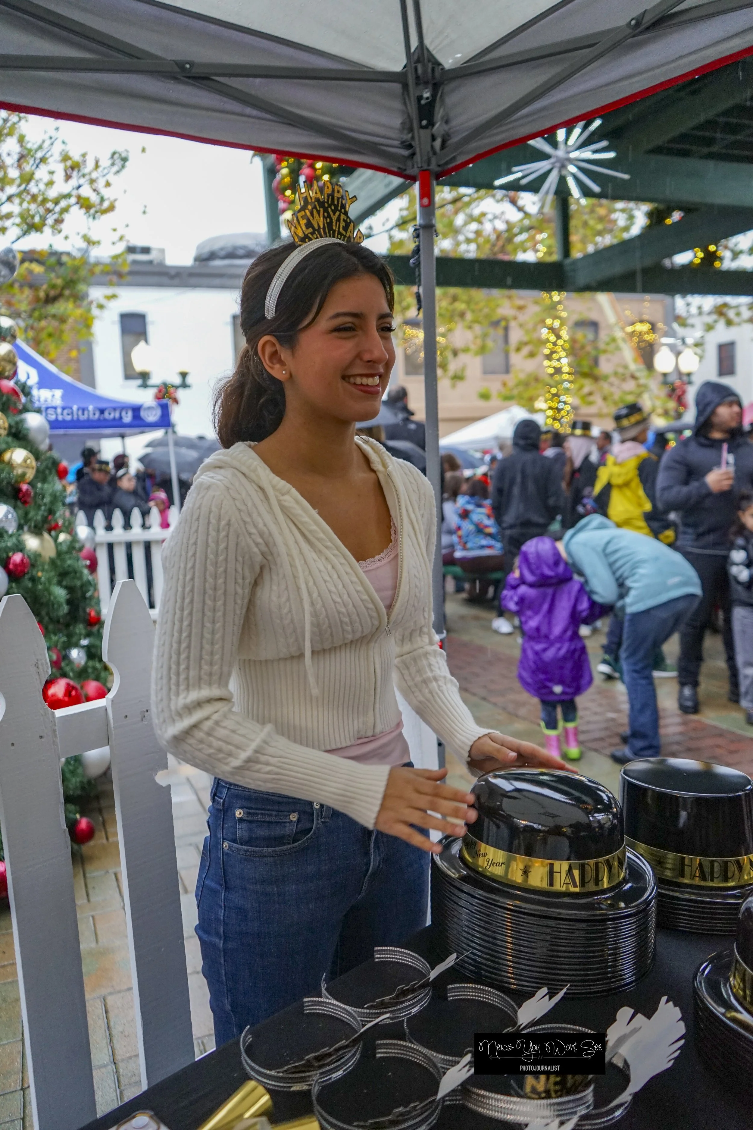  Lauren Mainez distributes New Year’s accessories to party goers at the annual beach ball drop at Ed Hales Park, Dec. 31, 2025. (photo by Brian Spears, Redlands Collective News) 