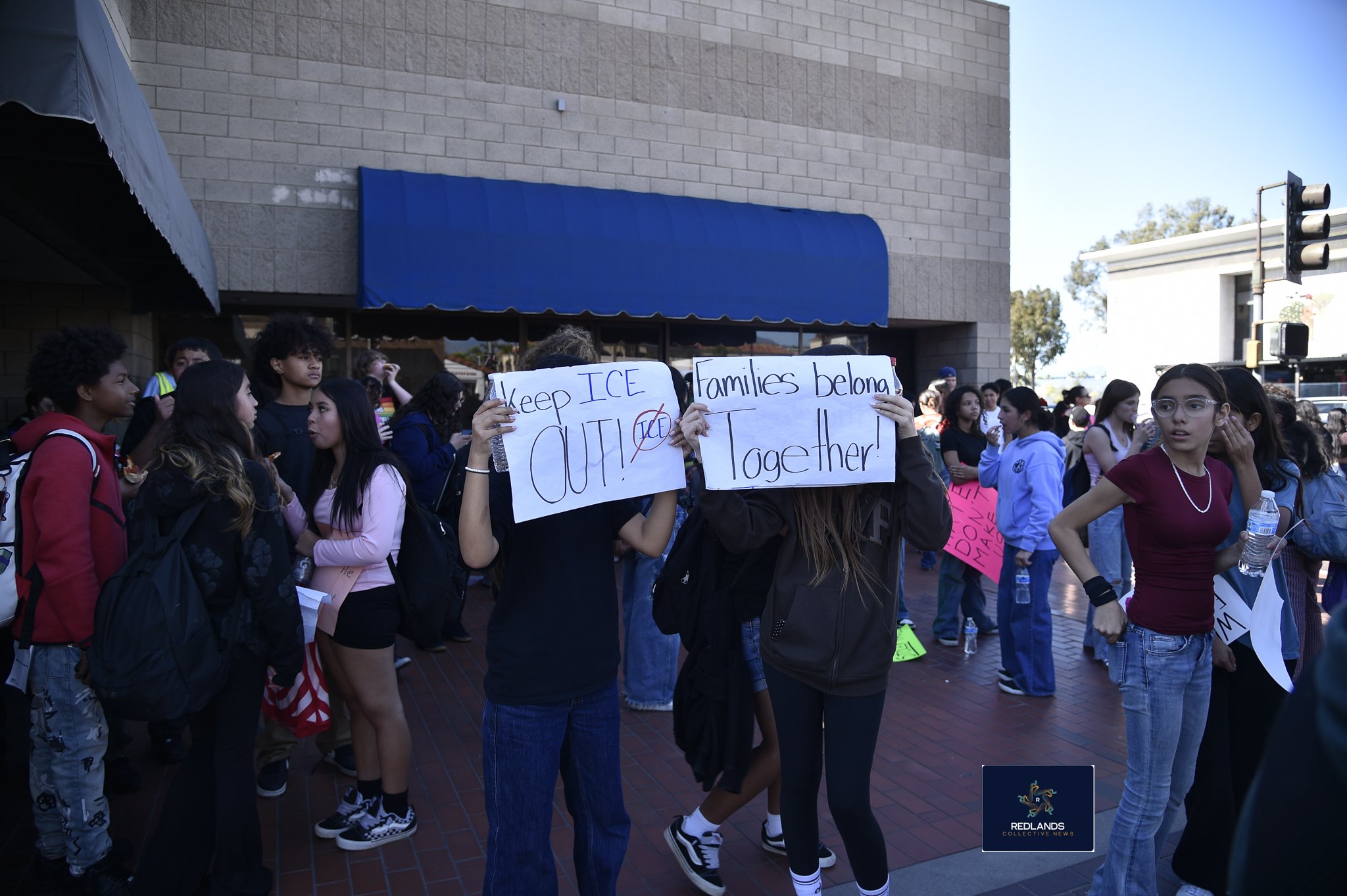  Students hold signs to protest against ICE Feb. 13, 2026 in downtown Redlands (Photo by Brian Spears, Redlands News Collective)  