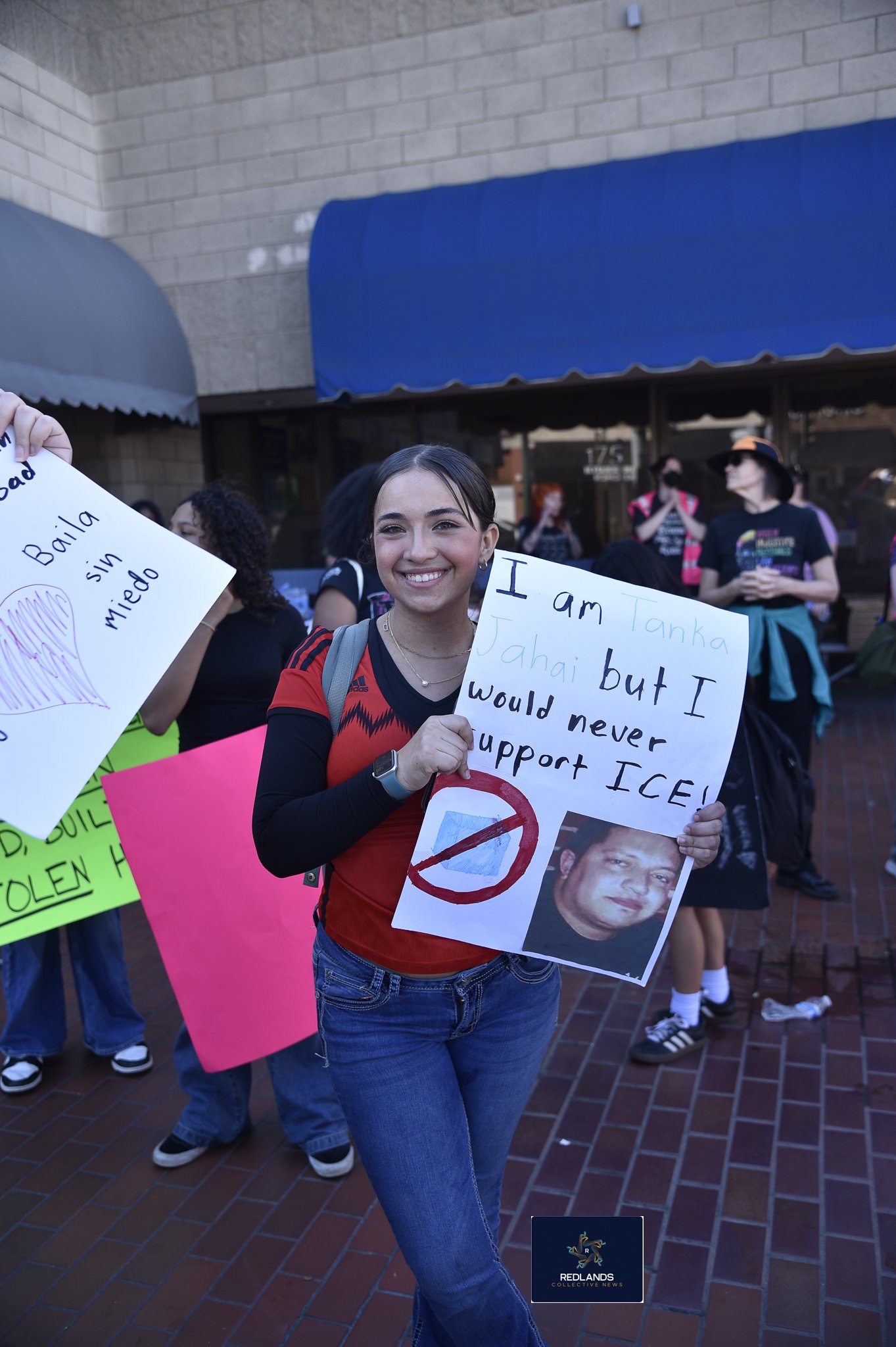  A student holds a sign against ICE Feb. 13, 2026 in downtown Redlands (Photo by Brian Spears, Redlands News Collective)  