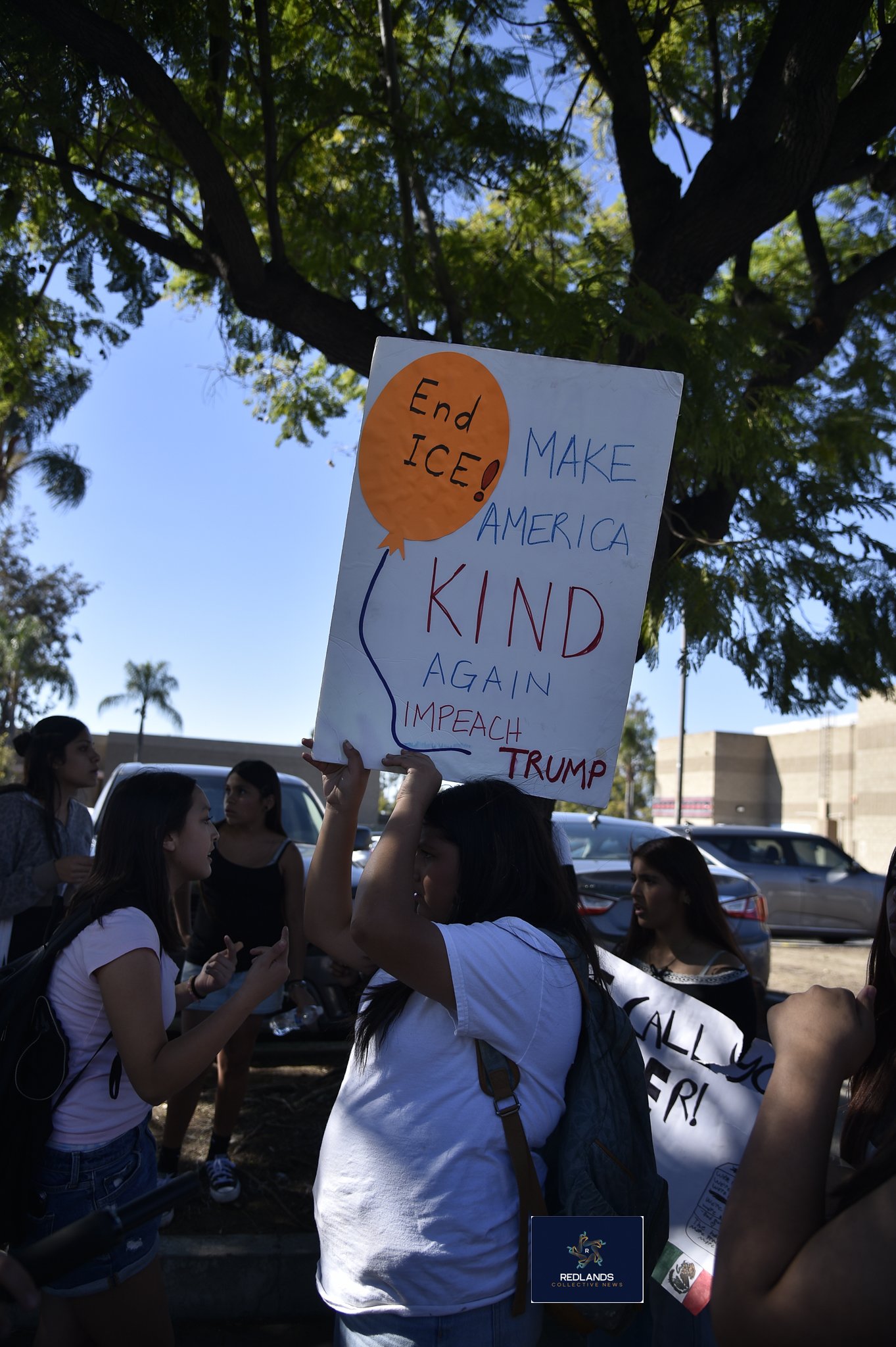  A student holds a sign against ICE Feb. 13, 2026 in downtown Redlands (Photo by Brian Spears, Redlands News Collective)  