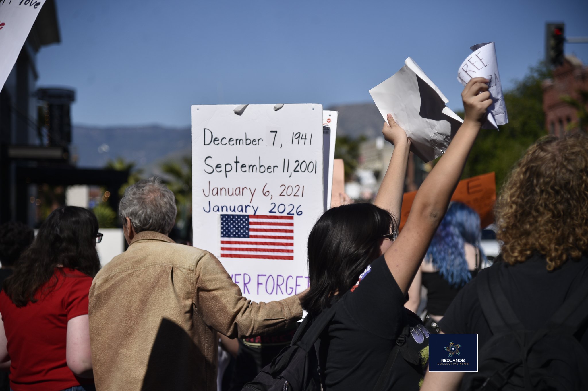  Former kindergarten teacher, John Smith, stands with students against ICE Feb. 13, 2026, in downtown Redlands (Photo by Brian Spears, Redlands News Collective)  