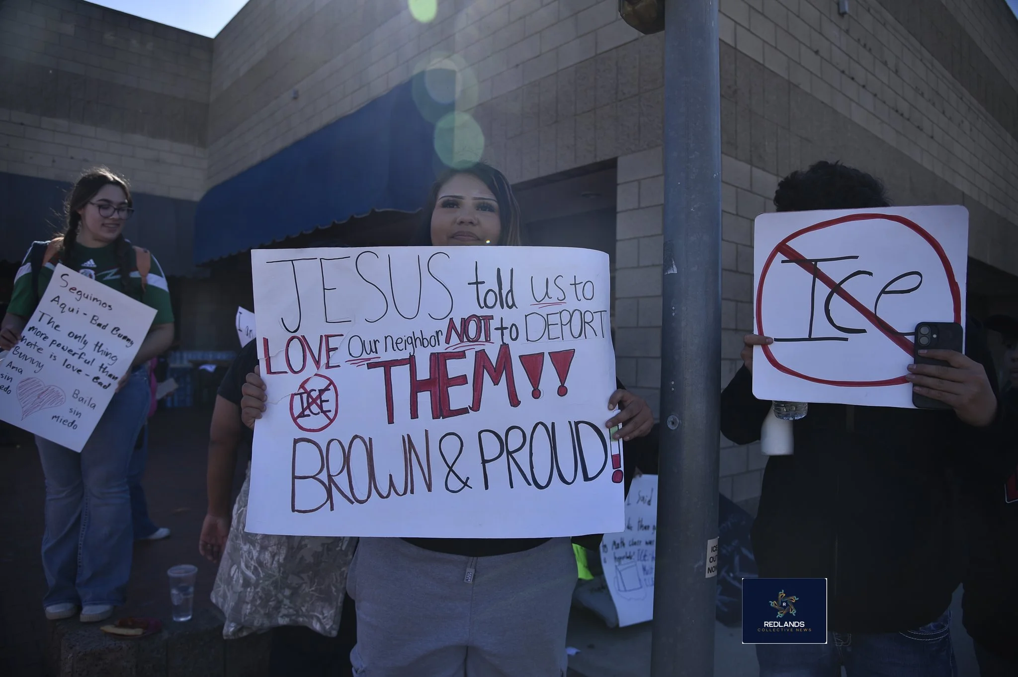  Anayah Diaz holds a sign aginst ICE Feb. 13, 2026 in downtown Redlands (Photo by Brian Spears, Redlands News Collective)  