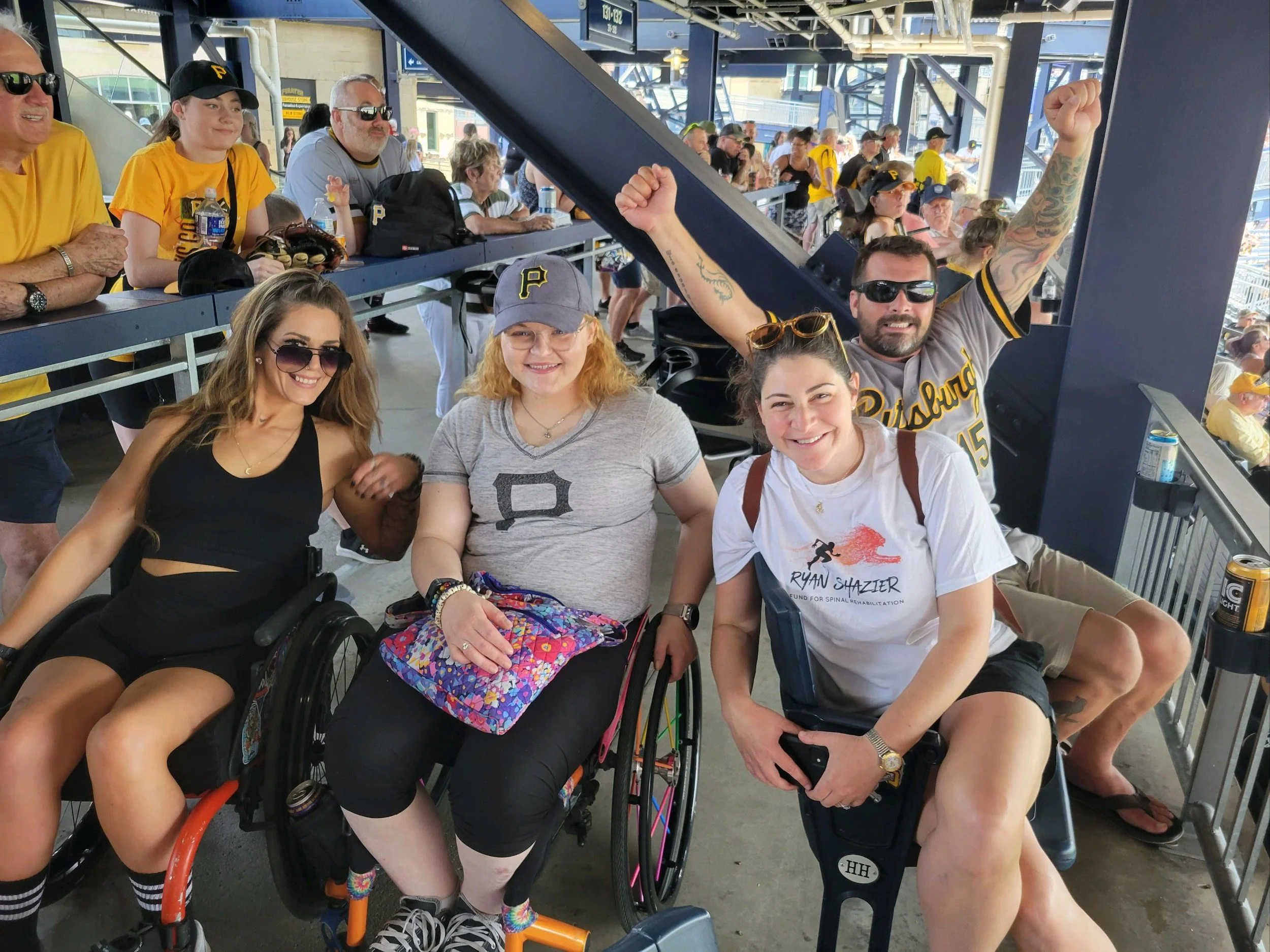 Group of people at a sports stadium, some in Pittsburgh Pirates attire, cheering and enjoying the game.